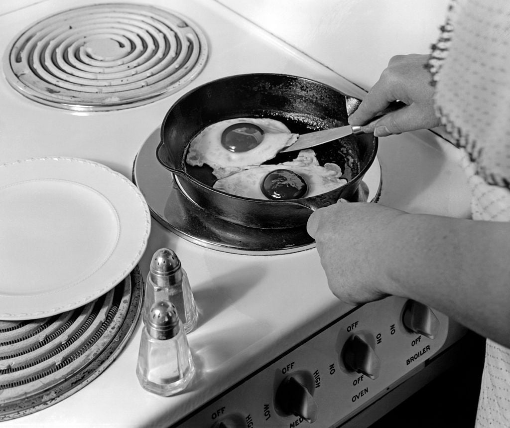 1940s 1950s WOMAN HANDS FRYING EGGS IN IRON SKILLET ON ELECTRIC STOVE SALT AND PEPPER SHAKERS