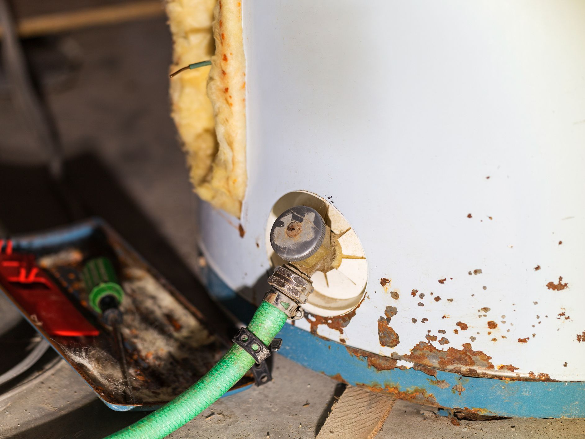 An old rusted out and broken domestic water heater.