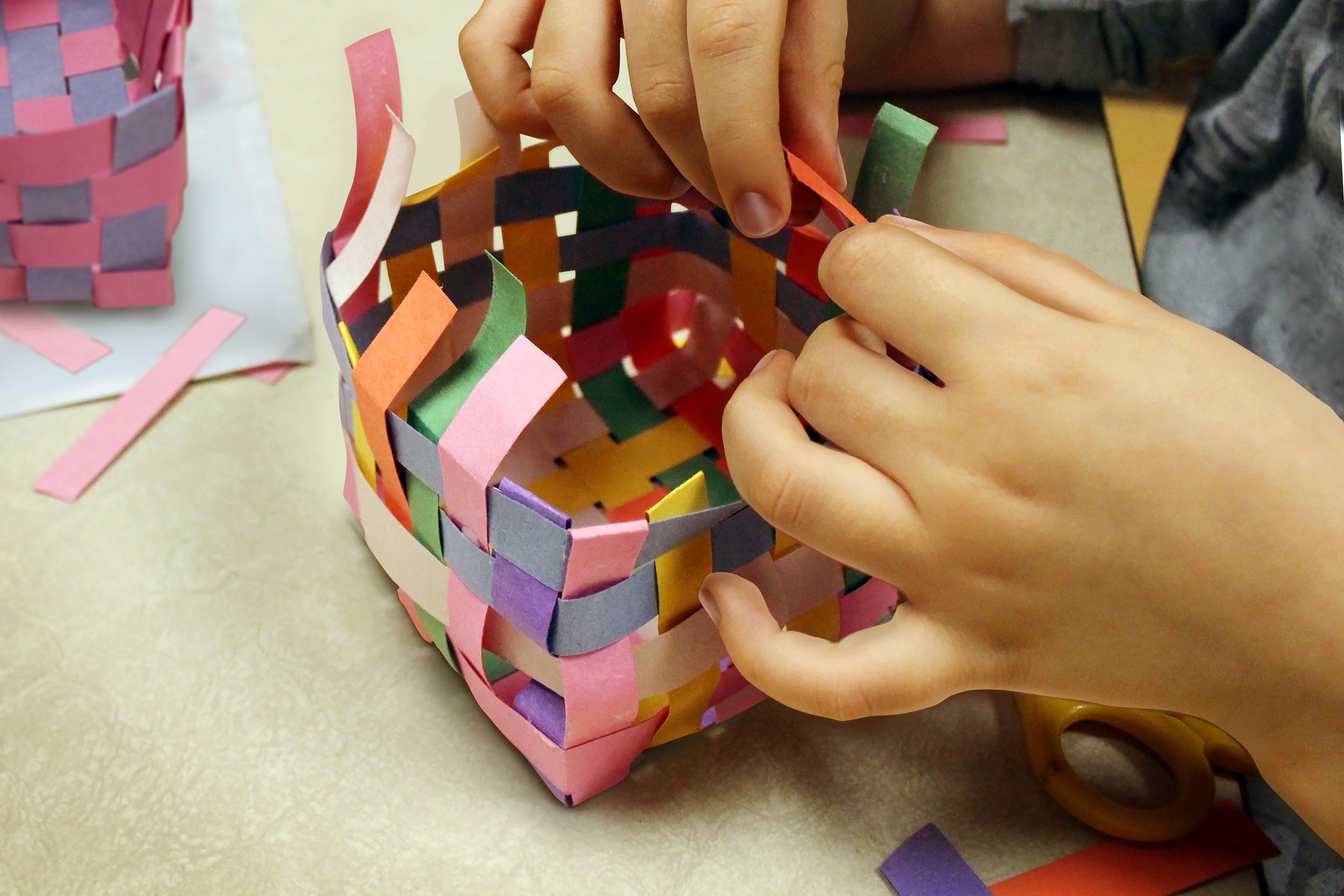 Closeup of child making a paper Easter basket