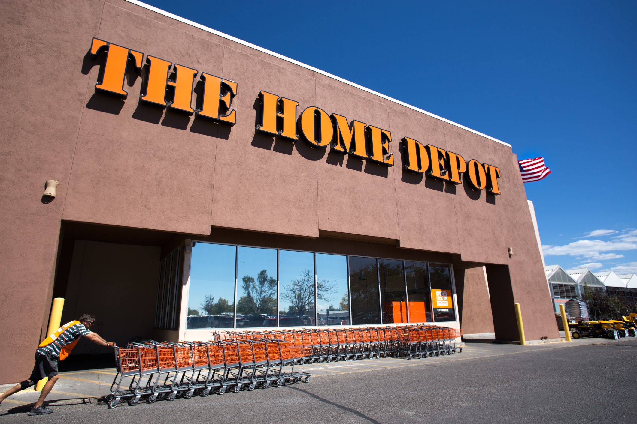 Santa Fe, NM: An employee pushes a line of shopping carts in front of The Home Depot. The store is constructed in the Pueblo architectural style.