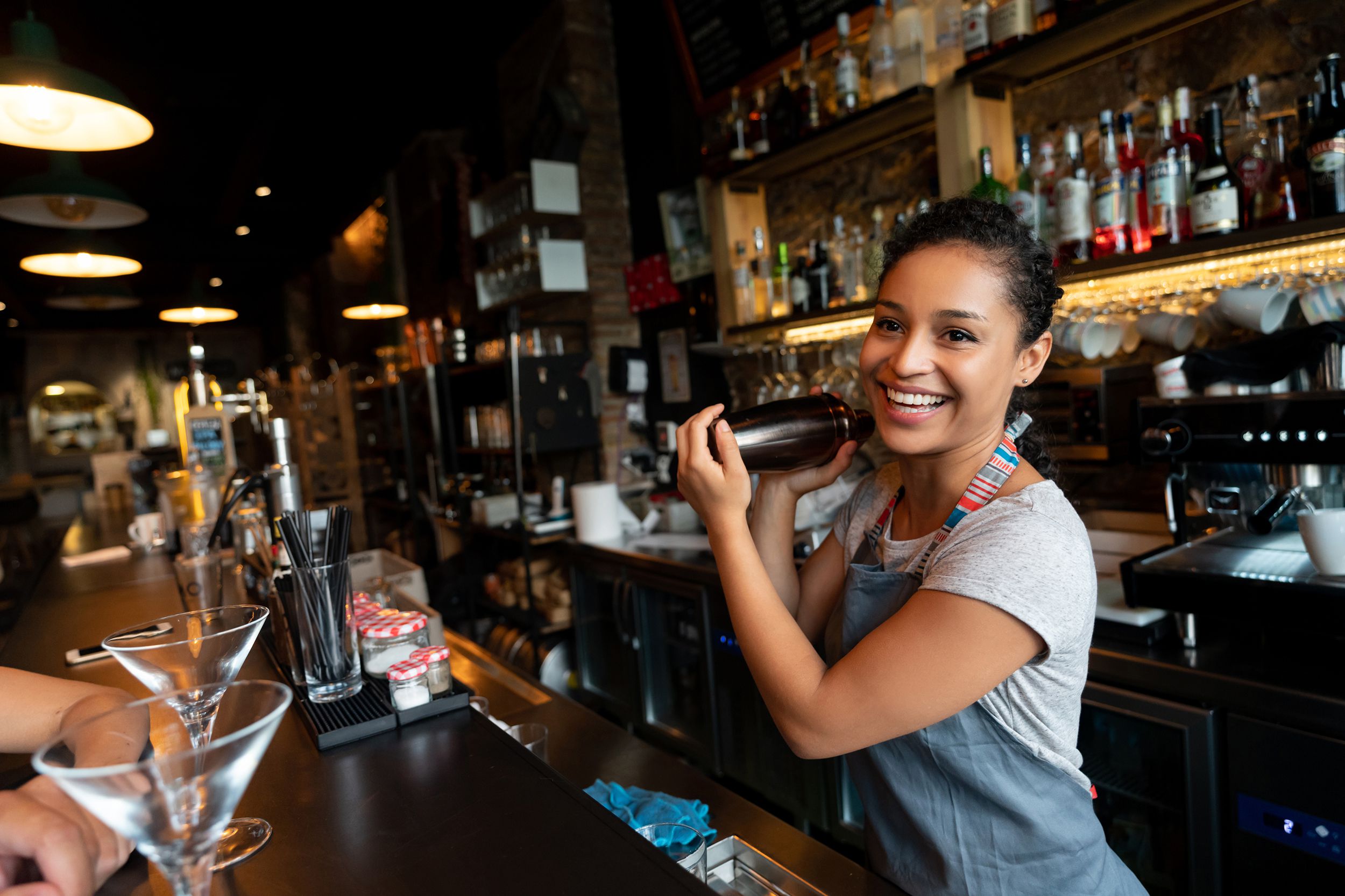 happy bartender mixing drinks at the bar