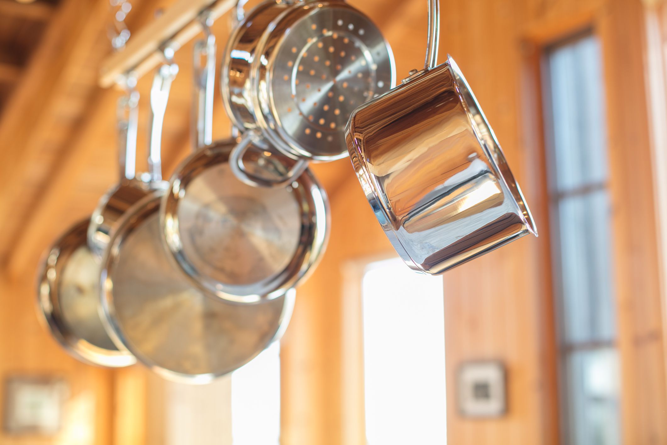 Pots and Pans hanging in Kitchen from wood rack