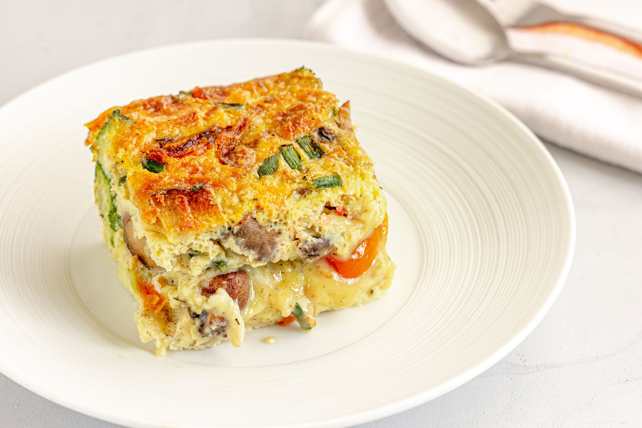 Slice of Breakfast Egg CAsserole on a Plate Close-Up Photo