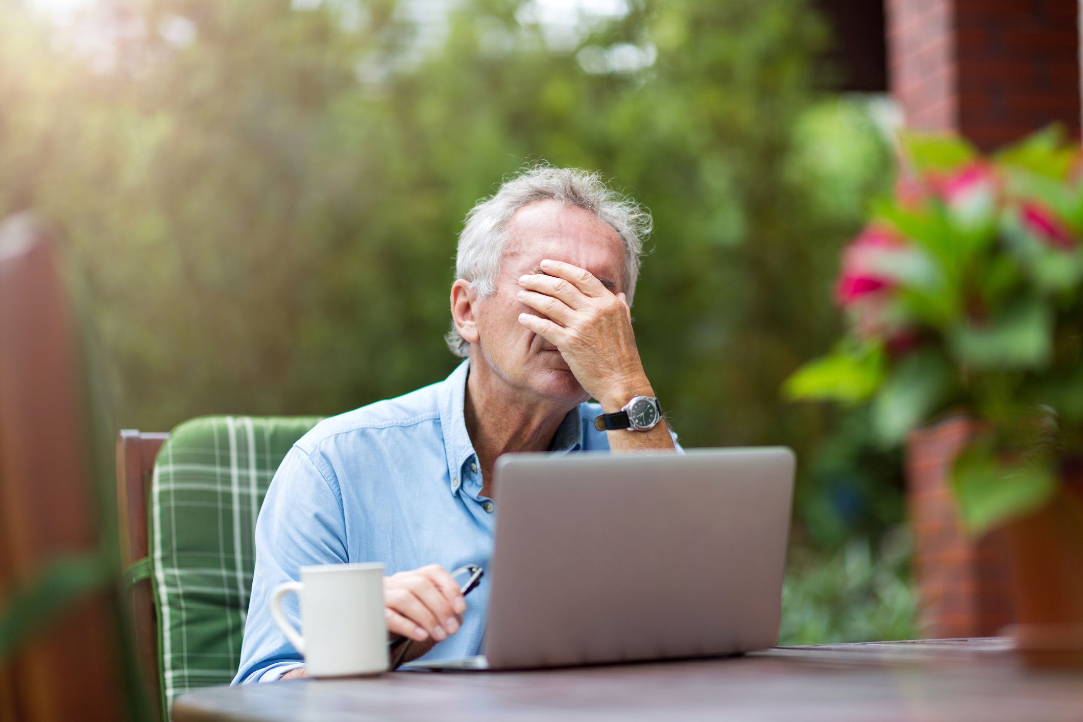 Senior man looking stressed while working on laptop