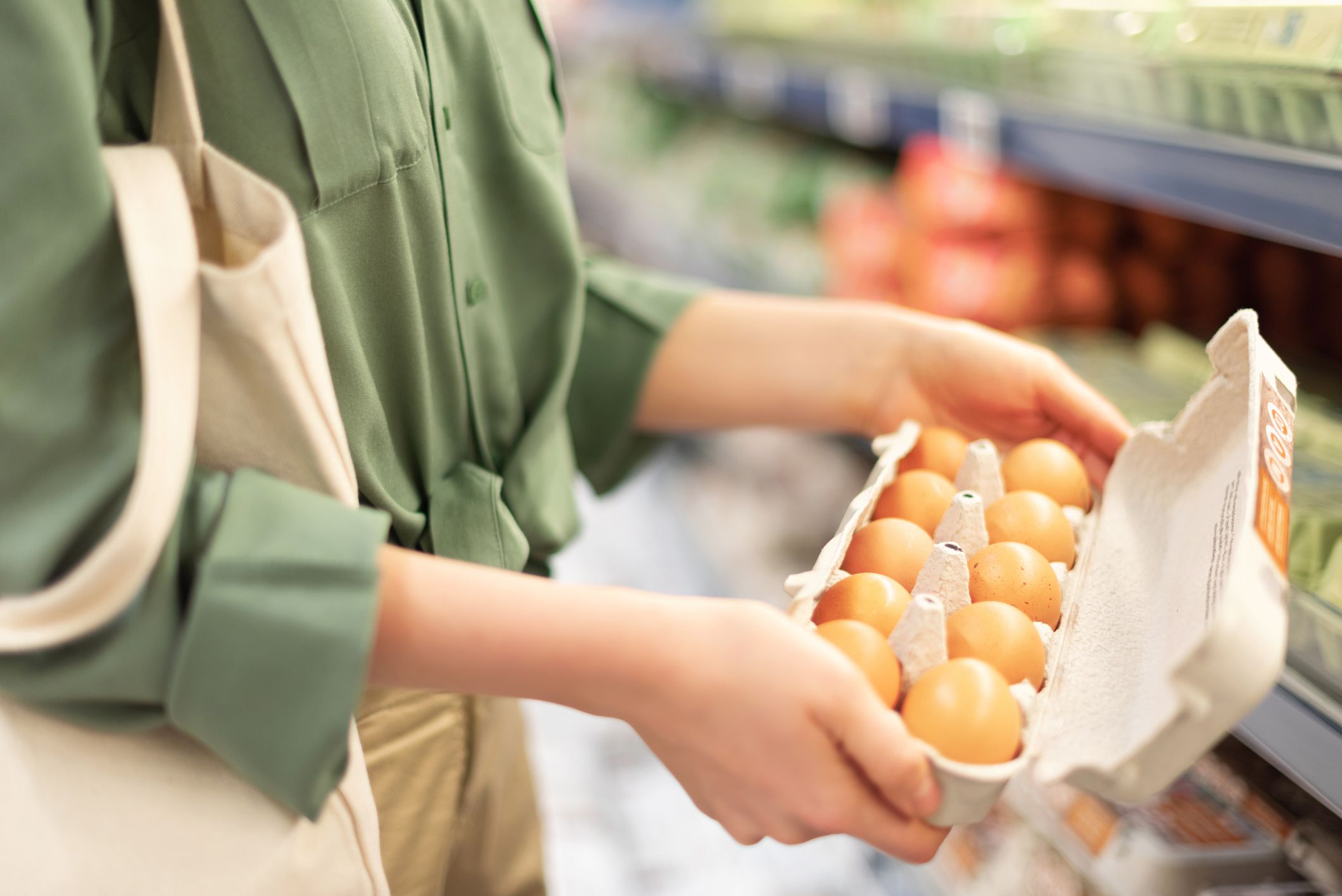 Girl at supermarket holding cotton shopper bag and buying eggs in craft package without plastic bags. Zero waste, plastic free concept. Sustainable lifestyle. Banner