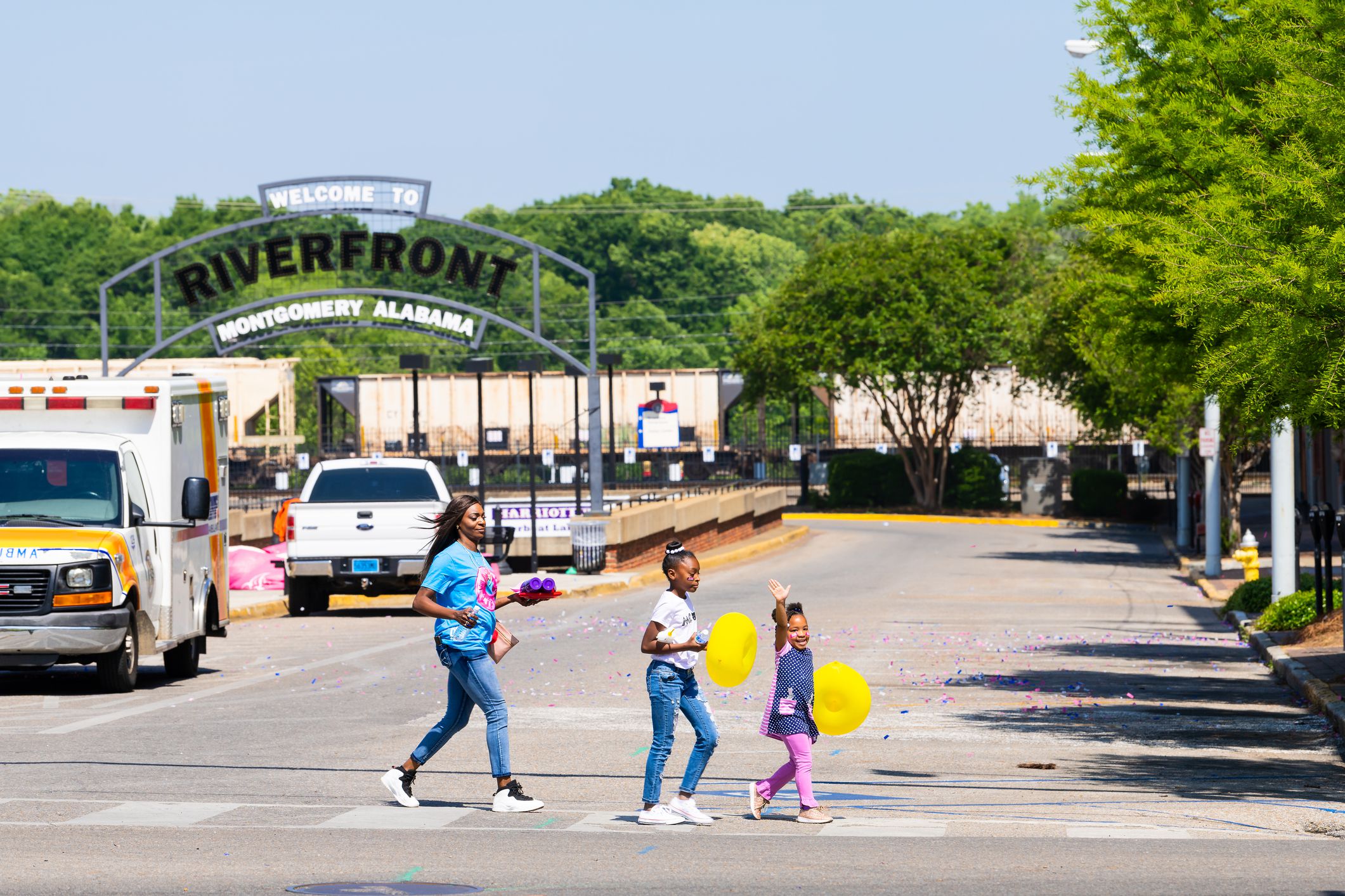 Montgomery, USA - April 21, 2018: Family people crossing crosswalk with balloons at riverfront after Walk of Life breast cancer event in capital city