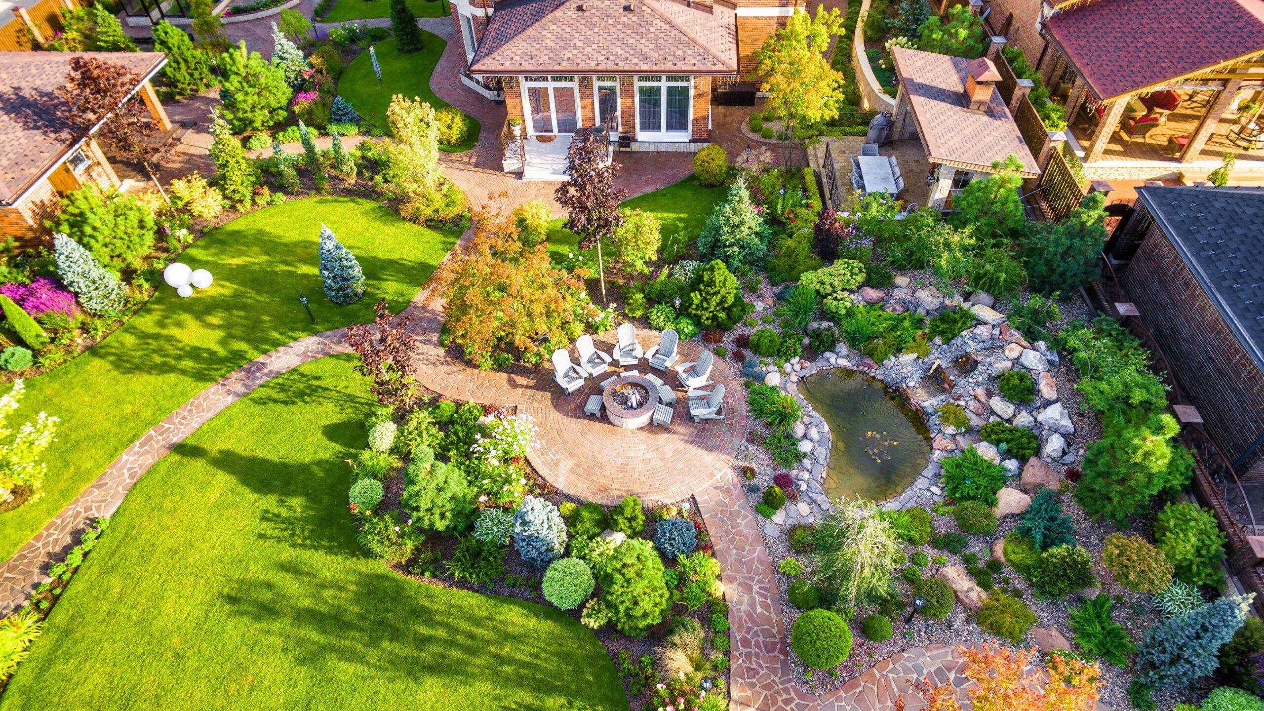 Moscow Region - Aug 24, 2019: Landscape design with patio at residential house taken from above. Beautiful landscaping in home garden in summer. Aerial panoramic view of landscaped garden in backyard.