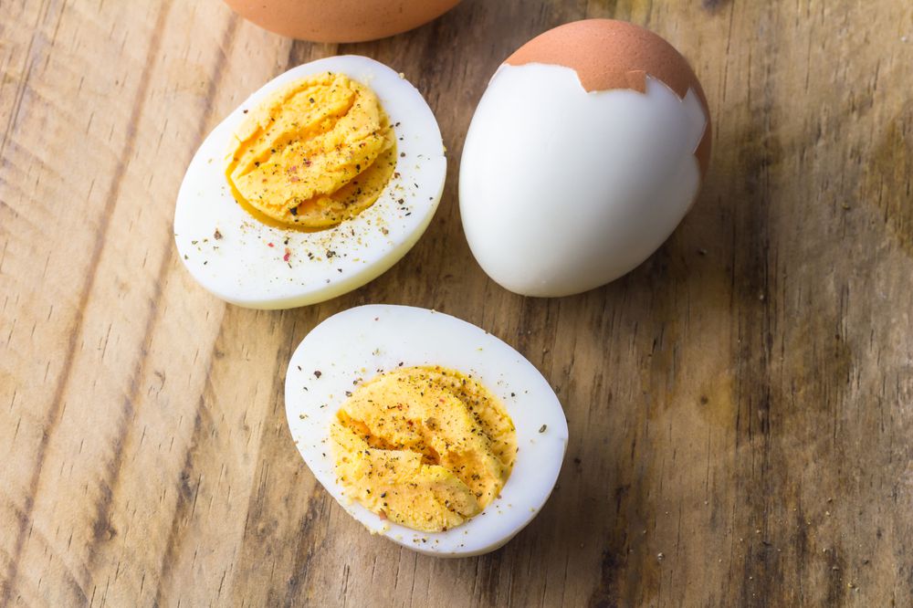 Boiled eggs on wooden board with pepper flakes