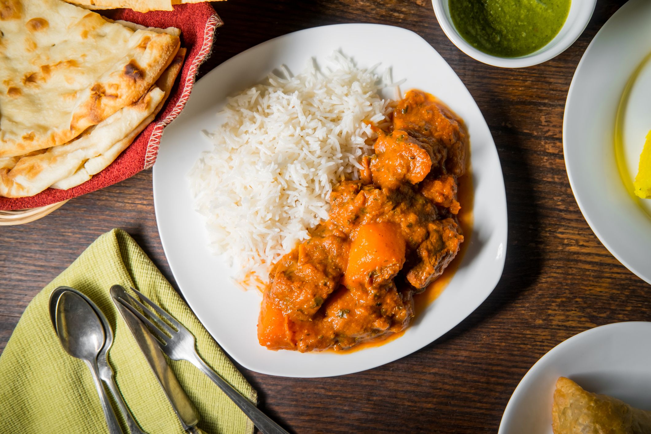 Indian lamb vindaloo dinner with several appetizers and naan bread
