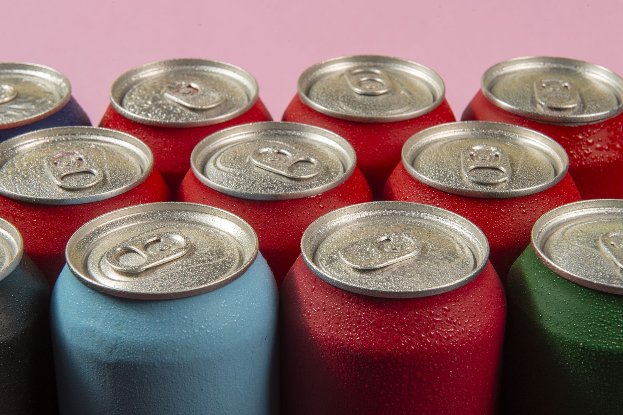 several aluminum soda cans in assorted colors in a table