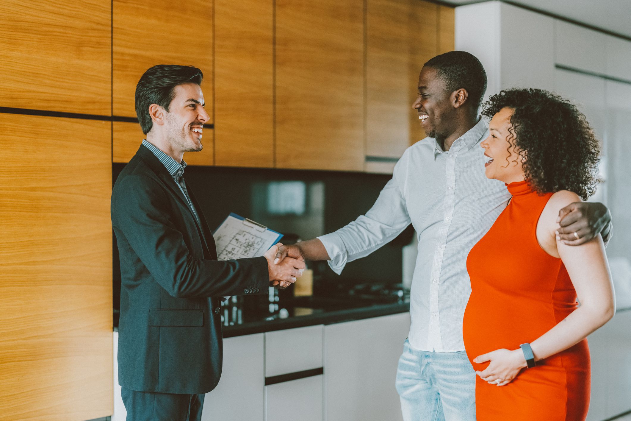 Real estate agent shows an apartment for sale to a pregnant woman and her husband