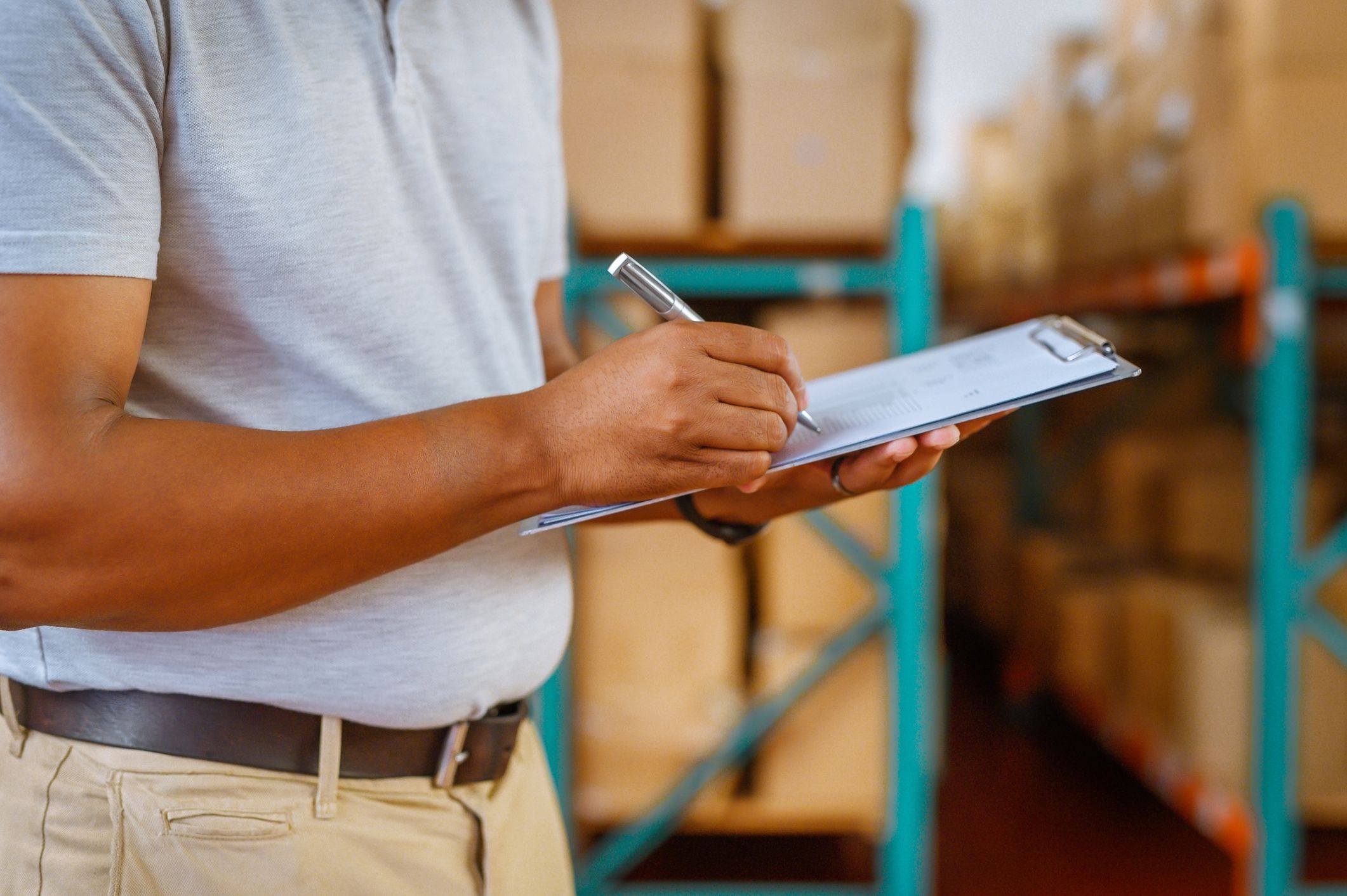 Shipping, logistics and delivery worker planning industrial supply chain manufacturing in warehouse. Wholesale manager writing paper for cargo stock, courier export and production in factory industry
