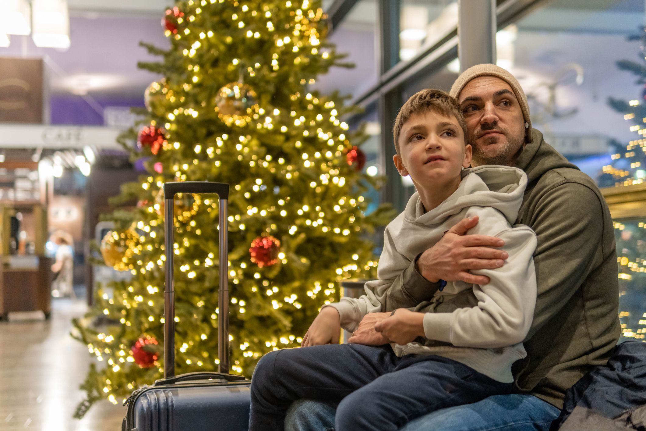 Father with his son waiting for airplane which is delayed due to bad weather conditions