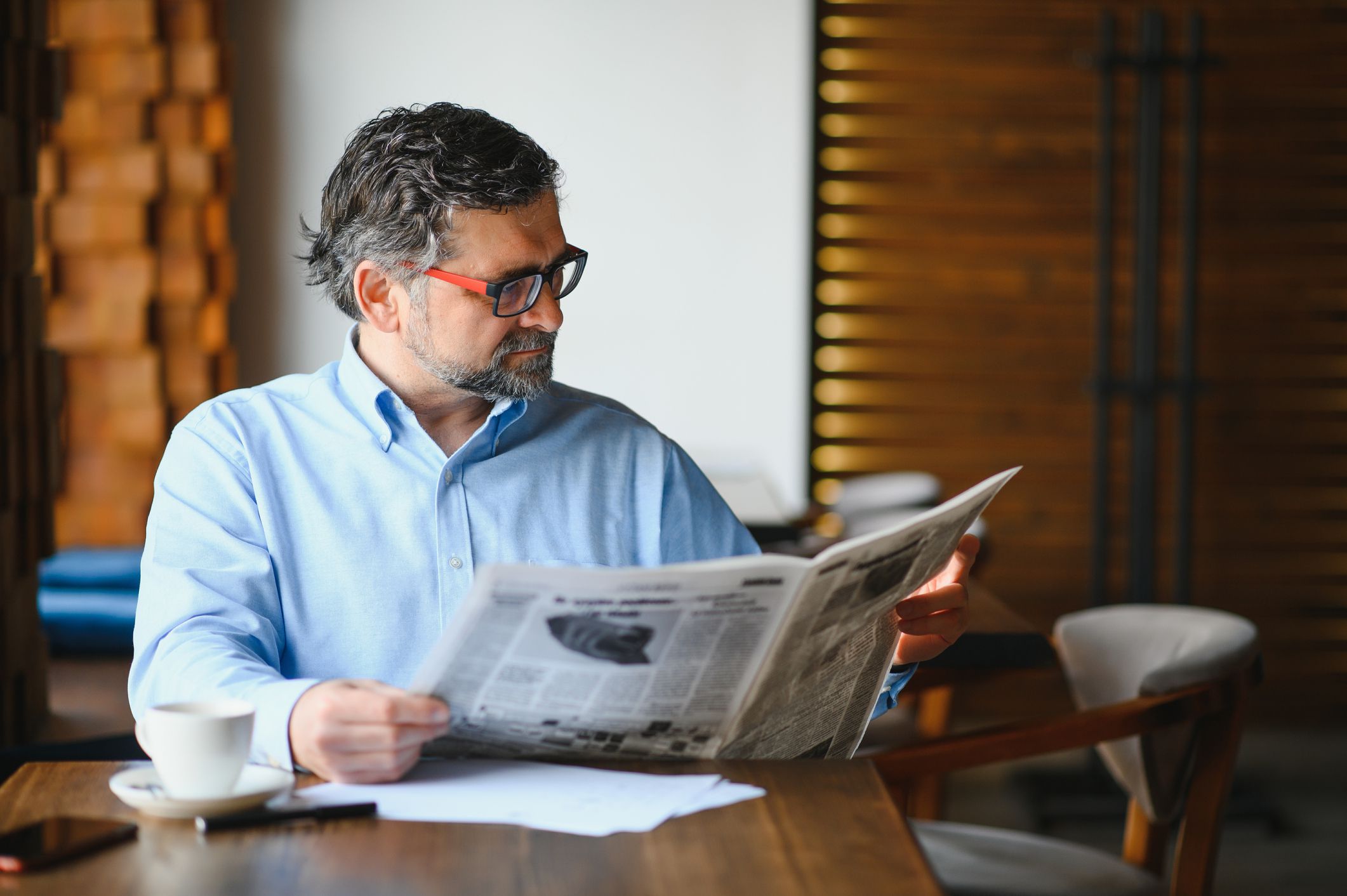 Newspaper in the morning. Senior businessman at his office riding newspapers