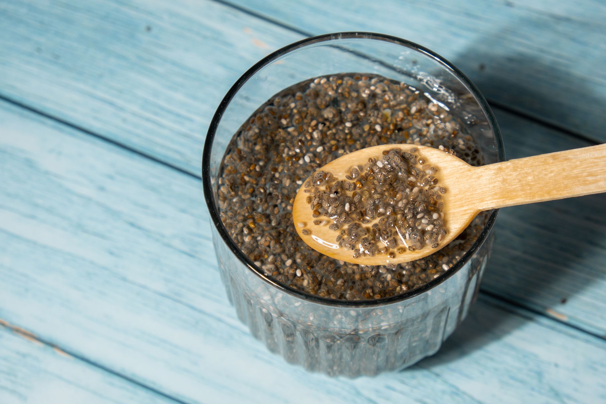 Preparing superfood water drink rich in Omega 3 fatty acids. Pouring coconut water. Adding soaked chia seeds and lemon detox Breakfast. Clean eating, weight loss, dieting food concept Vegetarian Healthy cooking process
