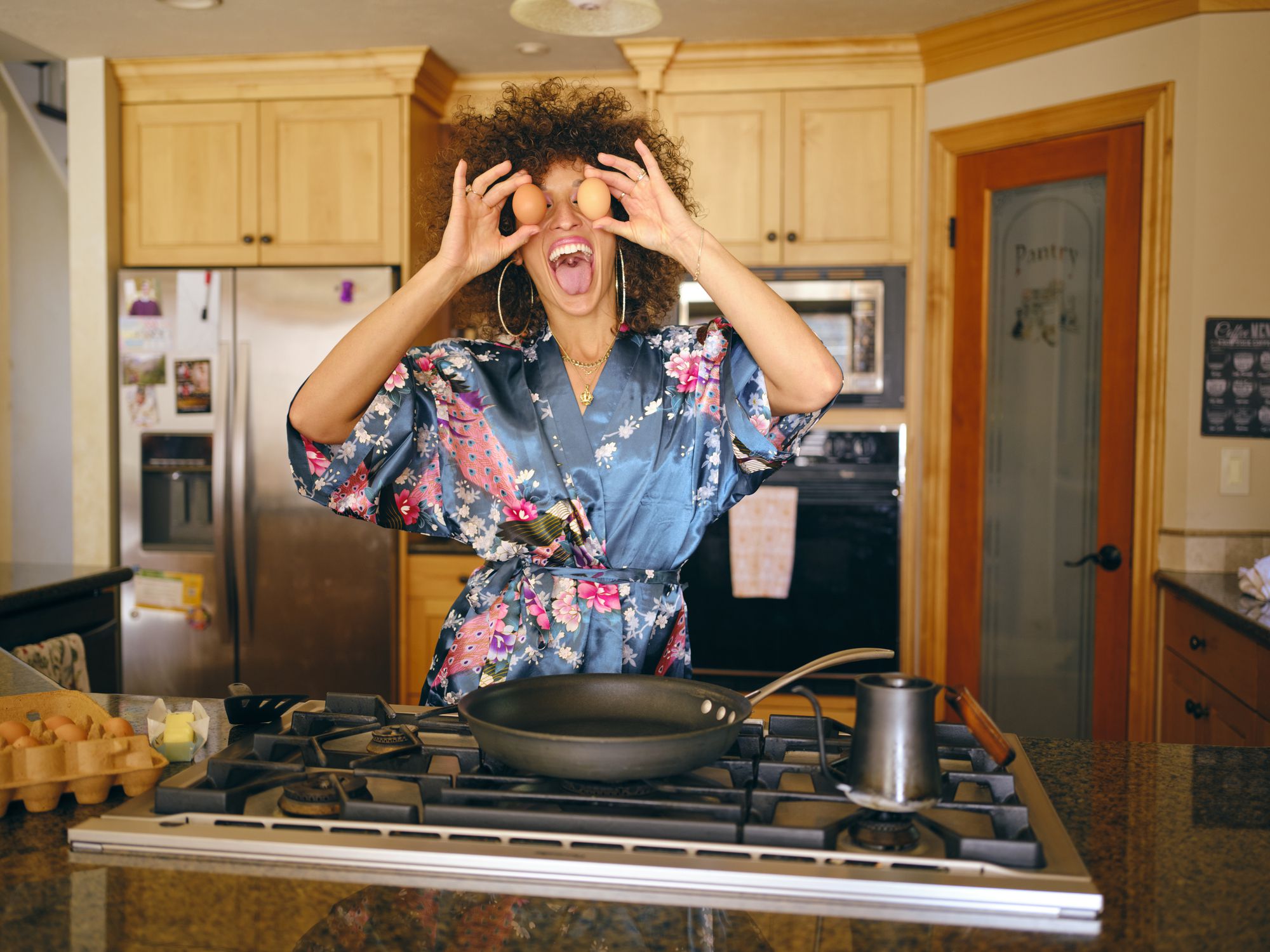 A woman at home in a kitchen with a 1970’s/1980’s vintage feel.