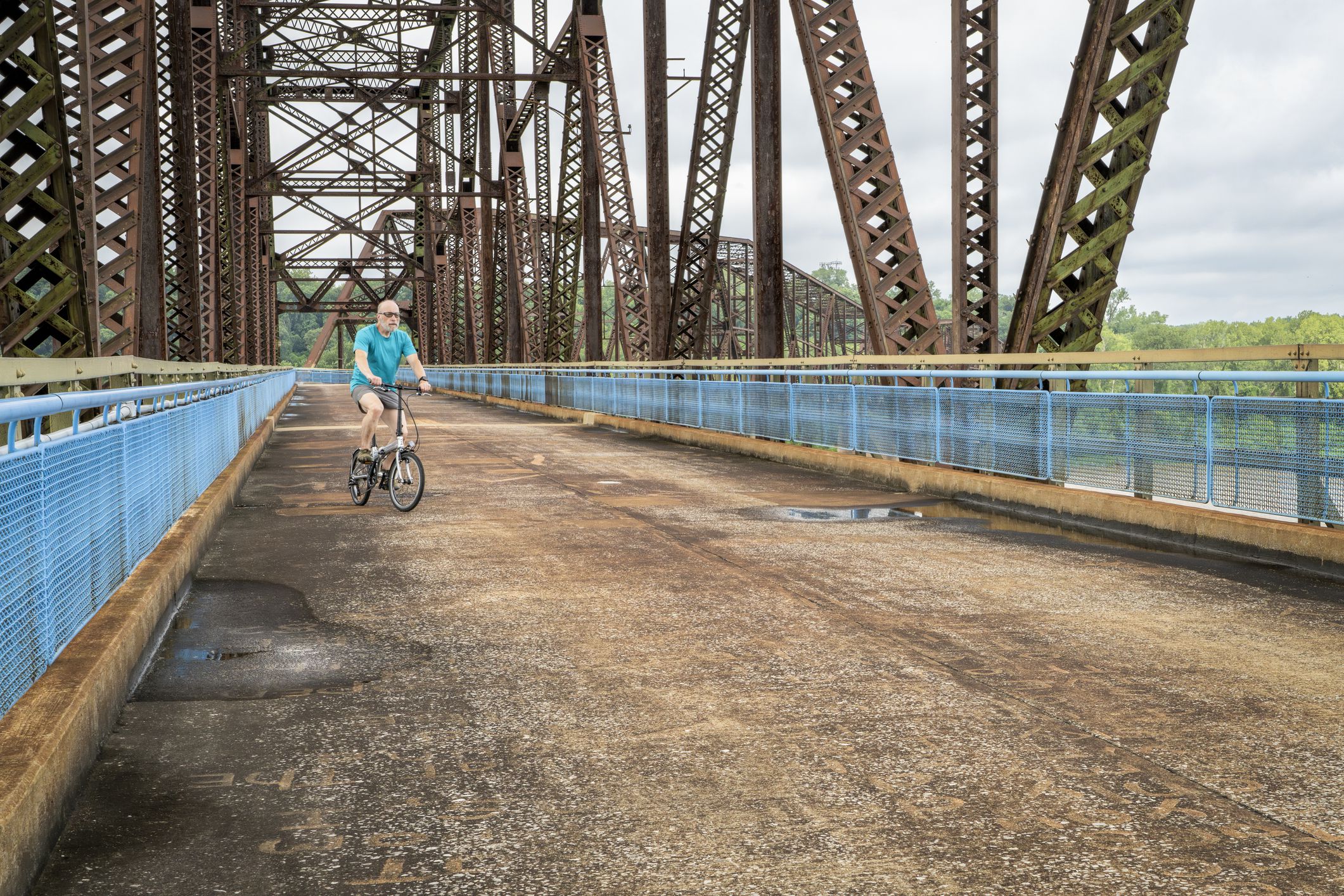 senior athletic man with a folding bike - biking on a historic Chain of Rock Bridge over Mississippi River above St Louis