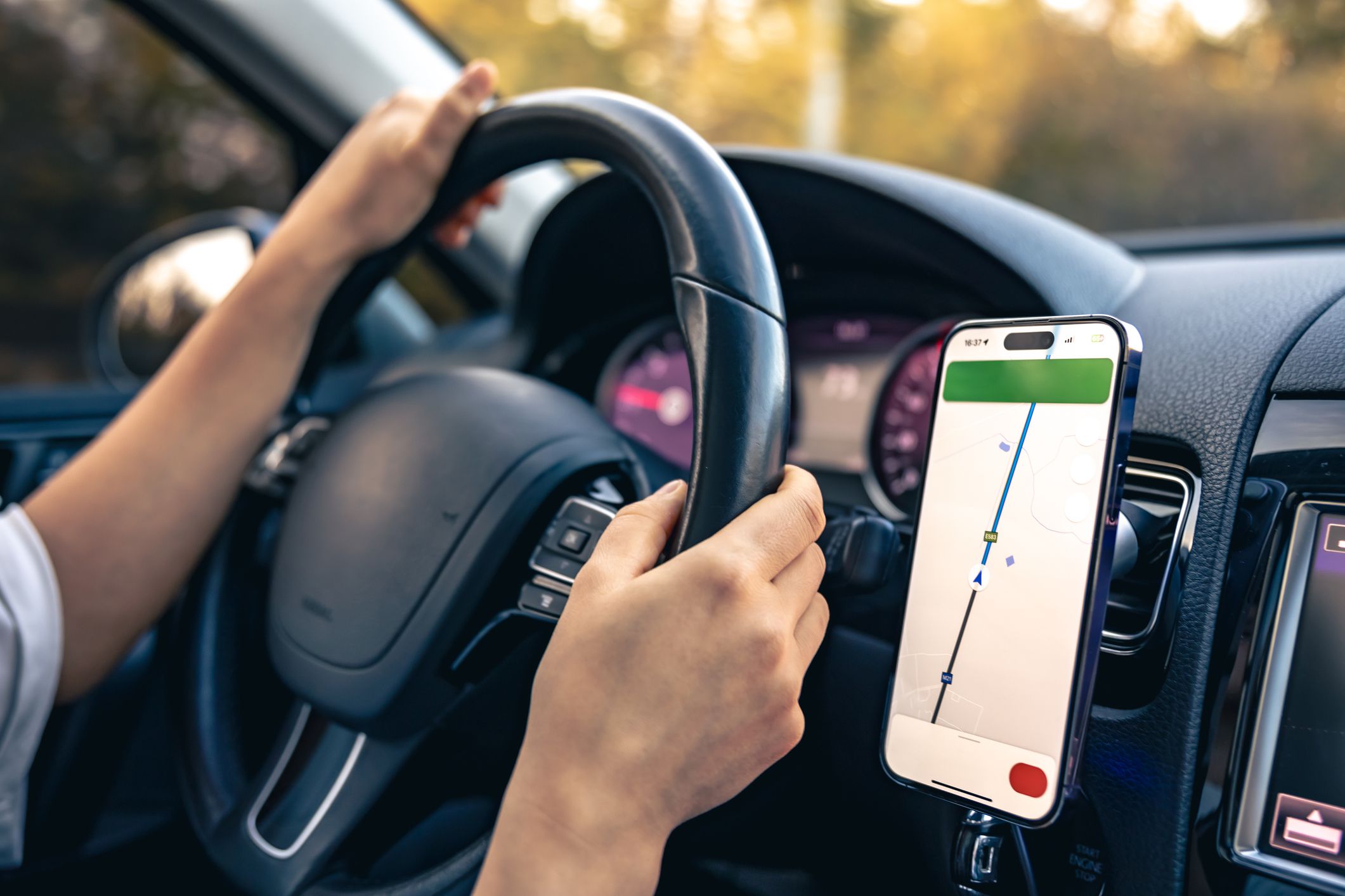 Woman using navigation or GPS on a mobile smartphone, viewing a location map online through a smartphone during a trip.