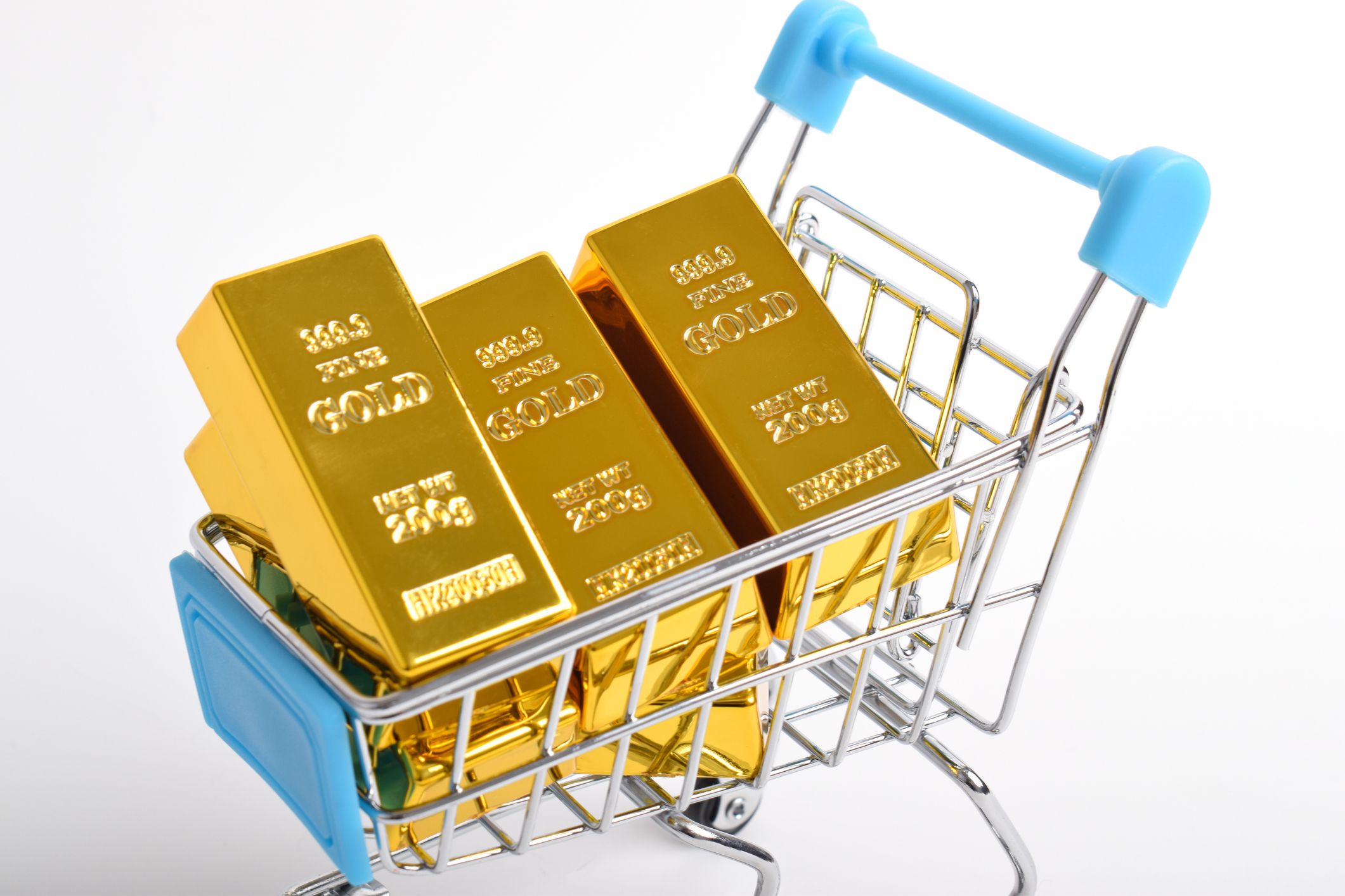Close up of Gold bars in shopping cart isolated on white background