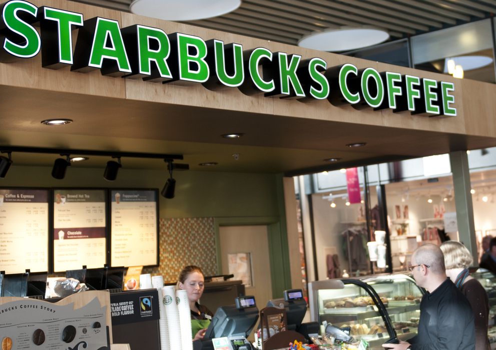Customers are served at Starbucks in Copenhagen Airport. Itaas one of the few Starbucks coffee shops in Scandinavia and the first one actually opened in Copenhagen Airport in 2007. Now the airport has two Starbucks.