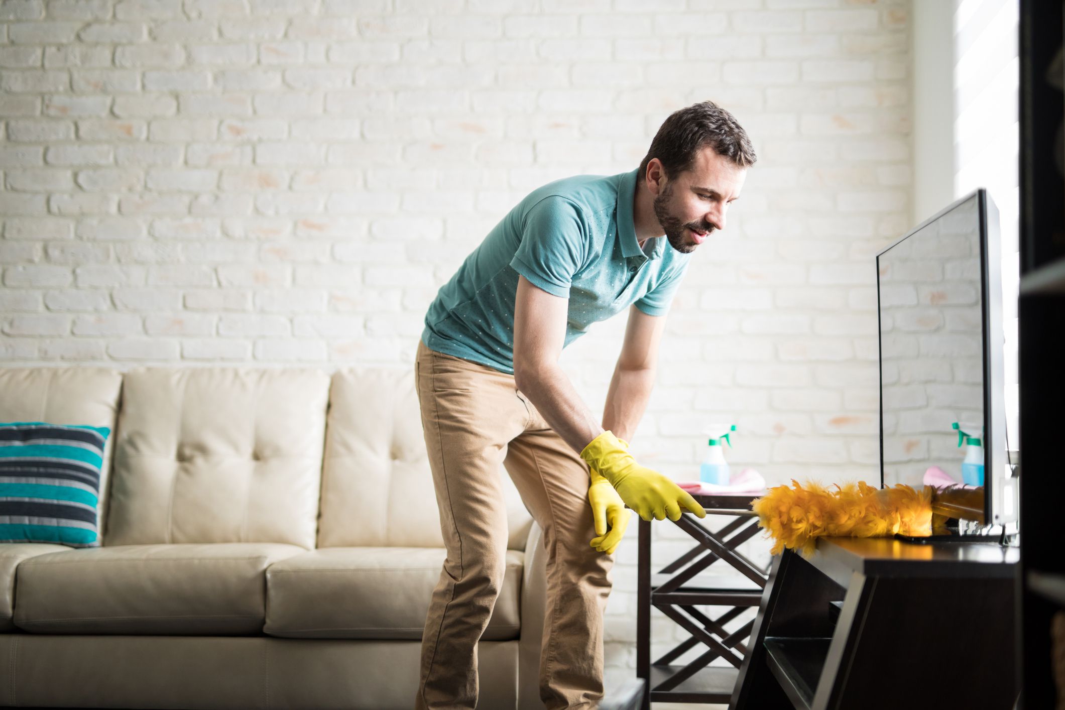 Attractive Latin man in his 30s doing house chores to maintain his apartment clean