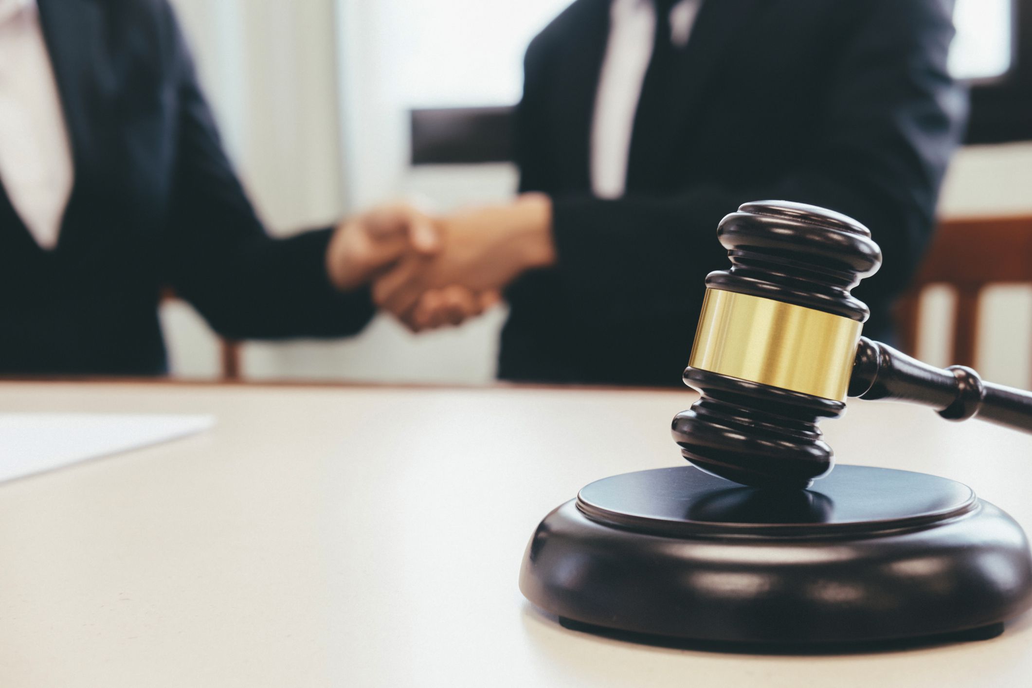 Law and Legal services concept. Lawyer and attorney having team meeting at law firm. Lawyer and businessman handshake.