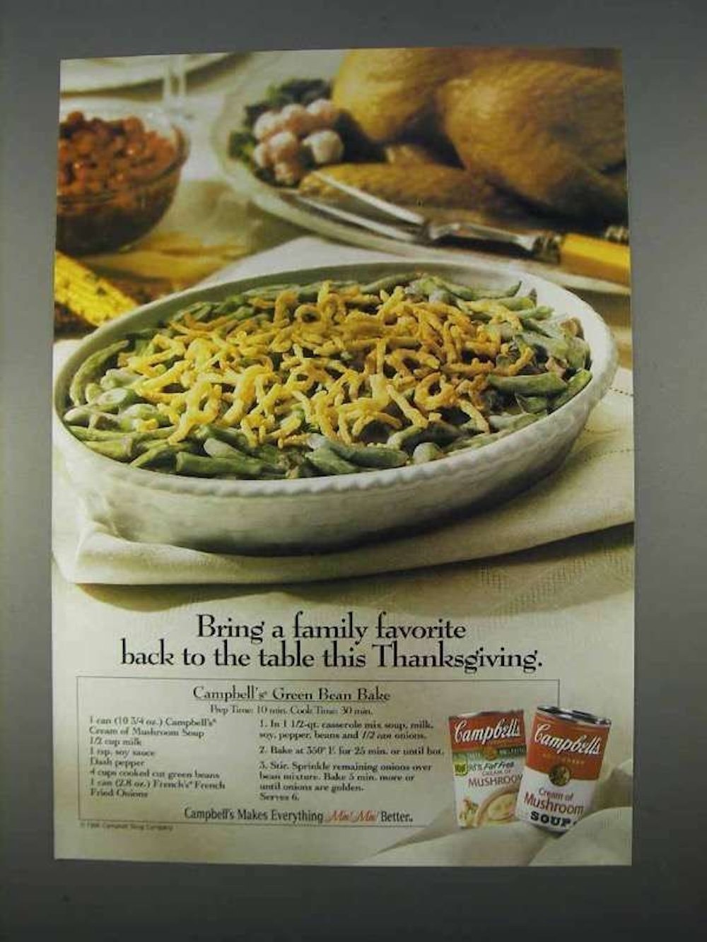 A vintage Campbell’s ad features a green bean casserole topped with crispy onions in a white dish, inspired by classic Back-of-the-Box Recipes. Cans of Campbell’s Cream of Mushroom Soup and French’s Crispy Onions sit beside Thanksgiving fare.