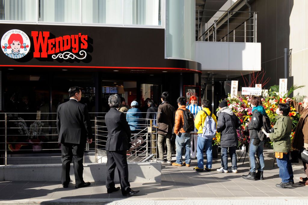 Customers form a queue to enter Wendy's during the re-opening ceremony of Wendy's first restaurant in Tokyo on December 27, 2011.