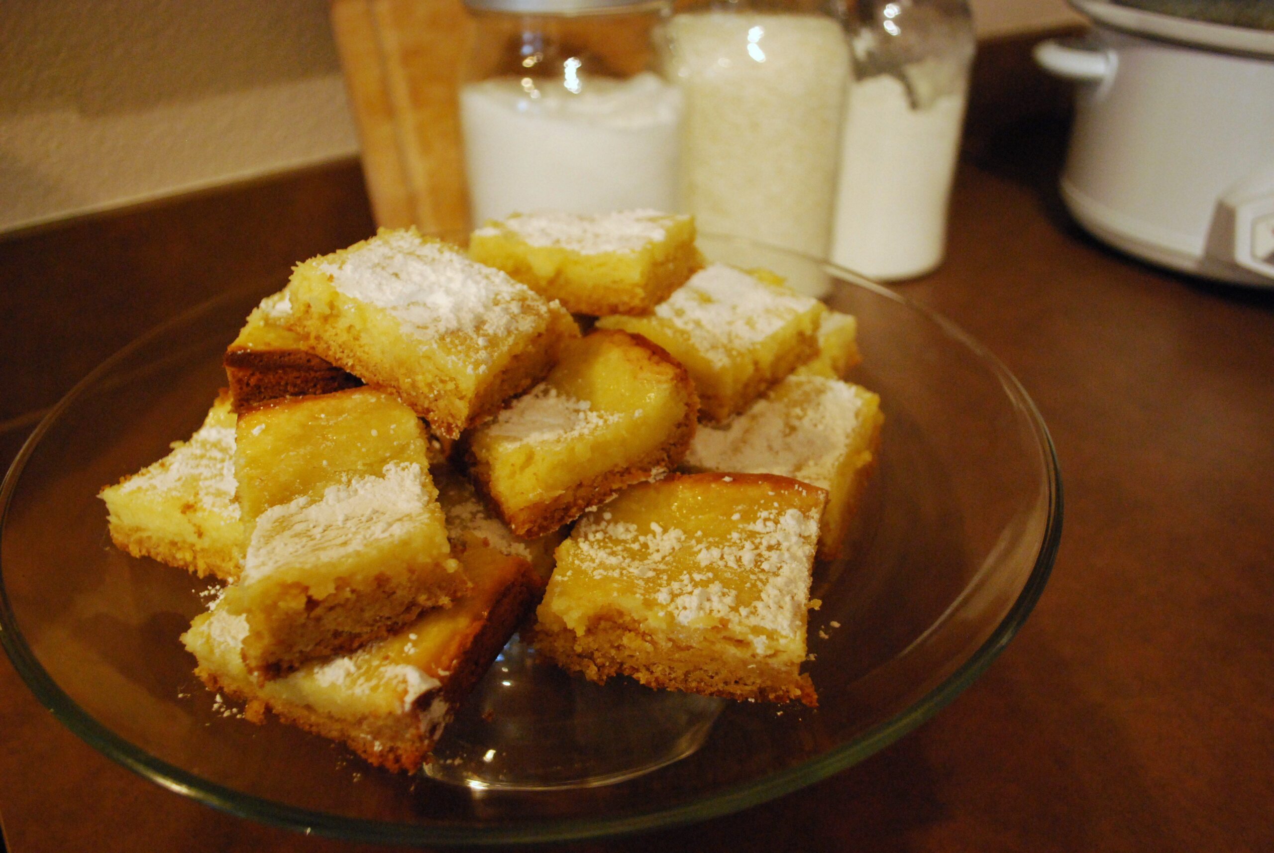 Gooey Butter Cake on a clear plate on a wood table