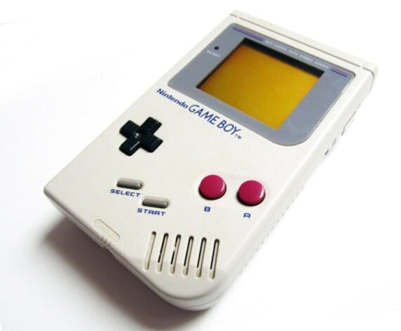 Original Nintendo Game Boy handheld console with a yellow screen, D-pad, and two maroon buttons.