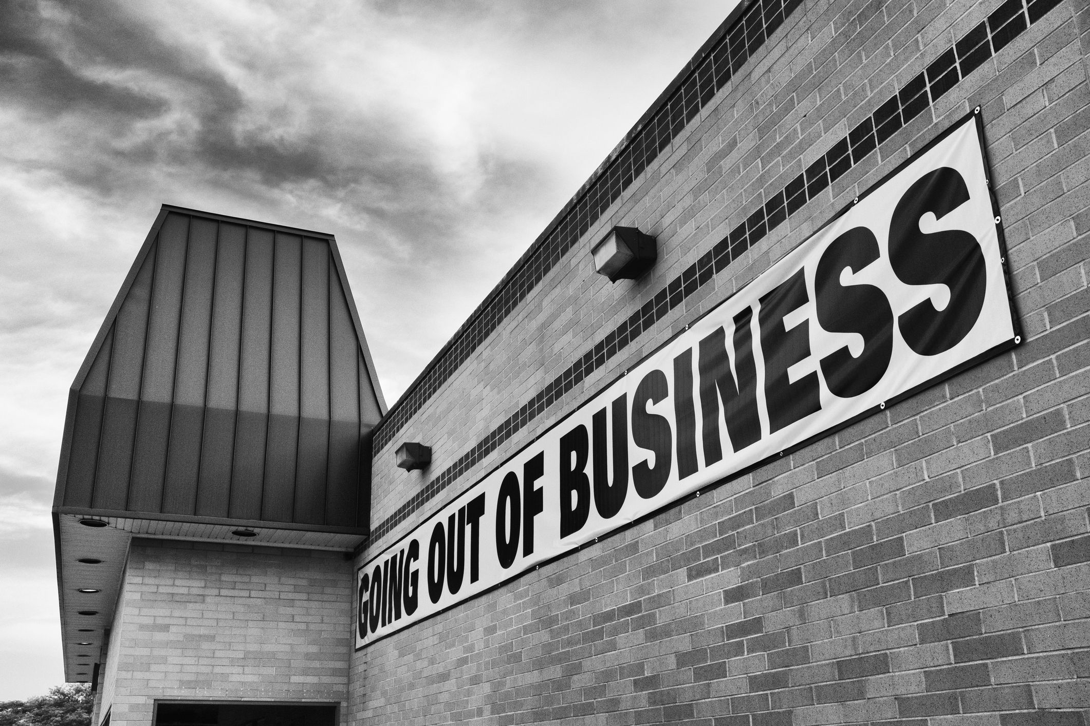 Going out of business sign on the side of a retail establishment.