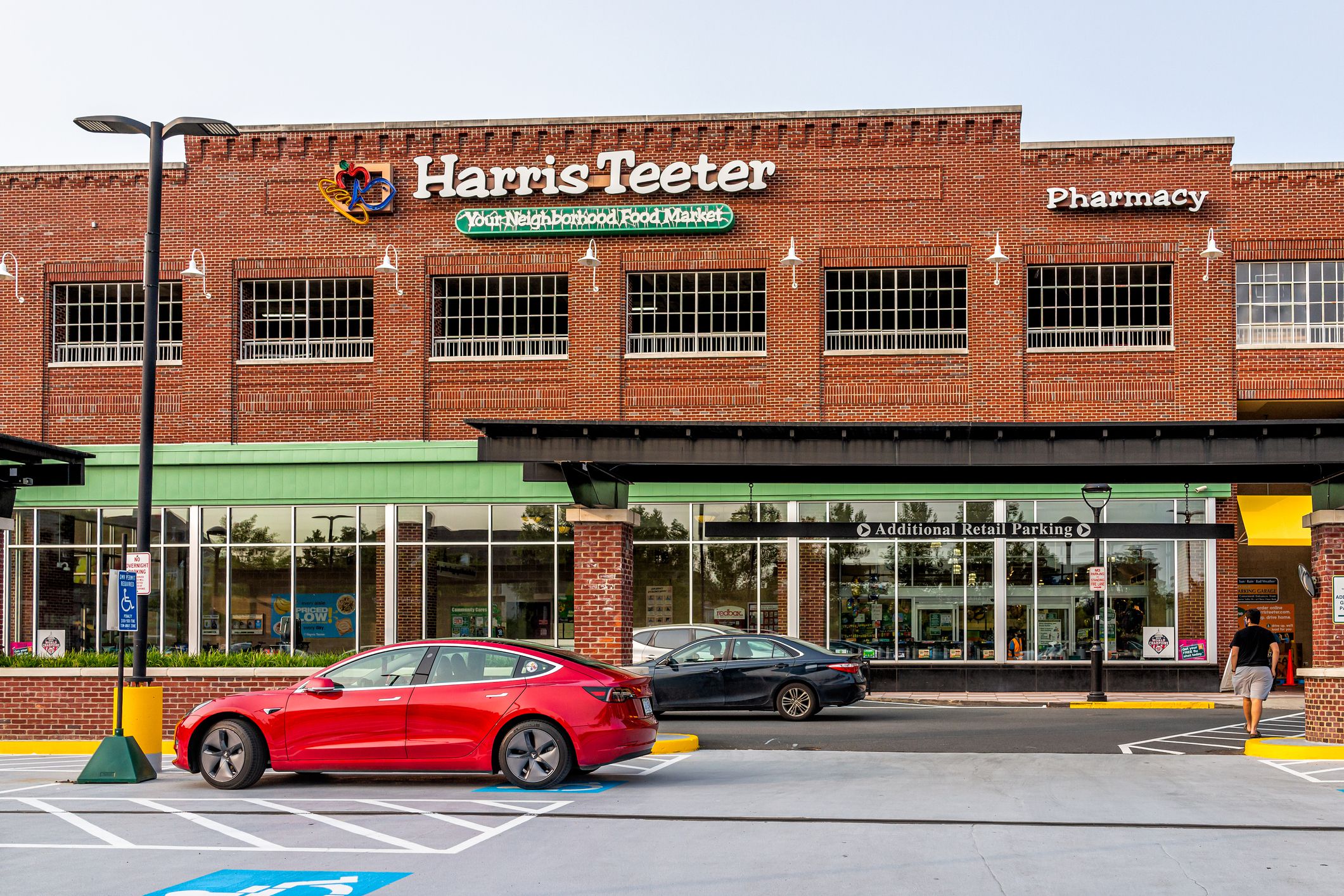 Herndon, USA - September 15, 2020: Sign for Harris Teeter Kroger grocery store business and blue sky in northern Virginia brick architecture parking lot