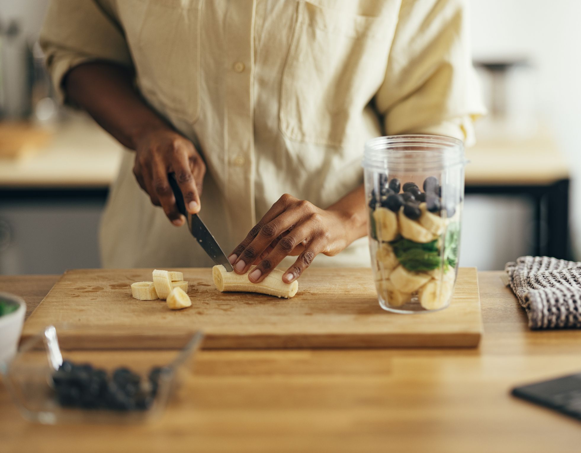 Unrecognizable African American woman making healthy breakfast on a kitchen table.