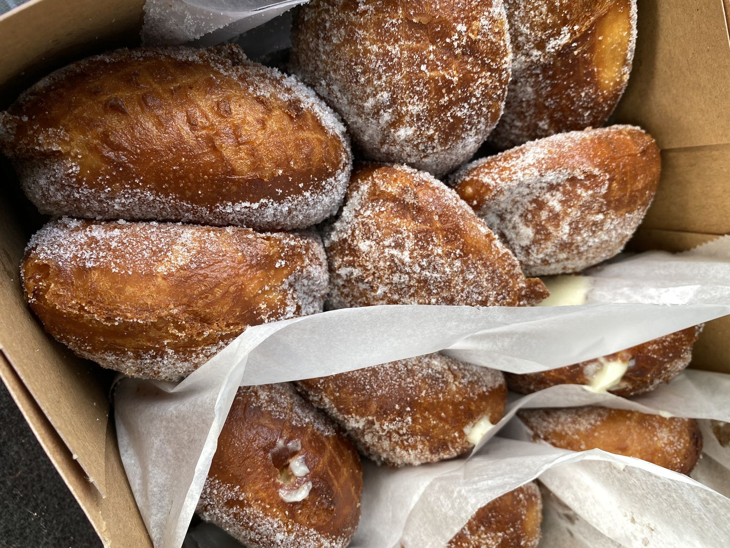 A bakery box of fresh-made malasadas - Portuguese donuts popular in Hawaii