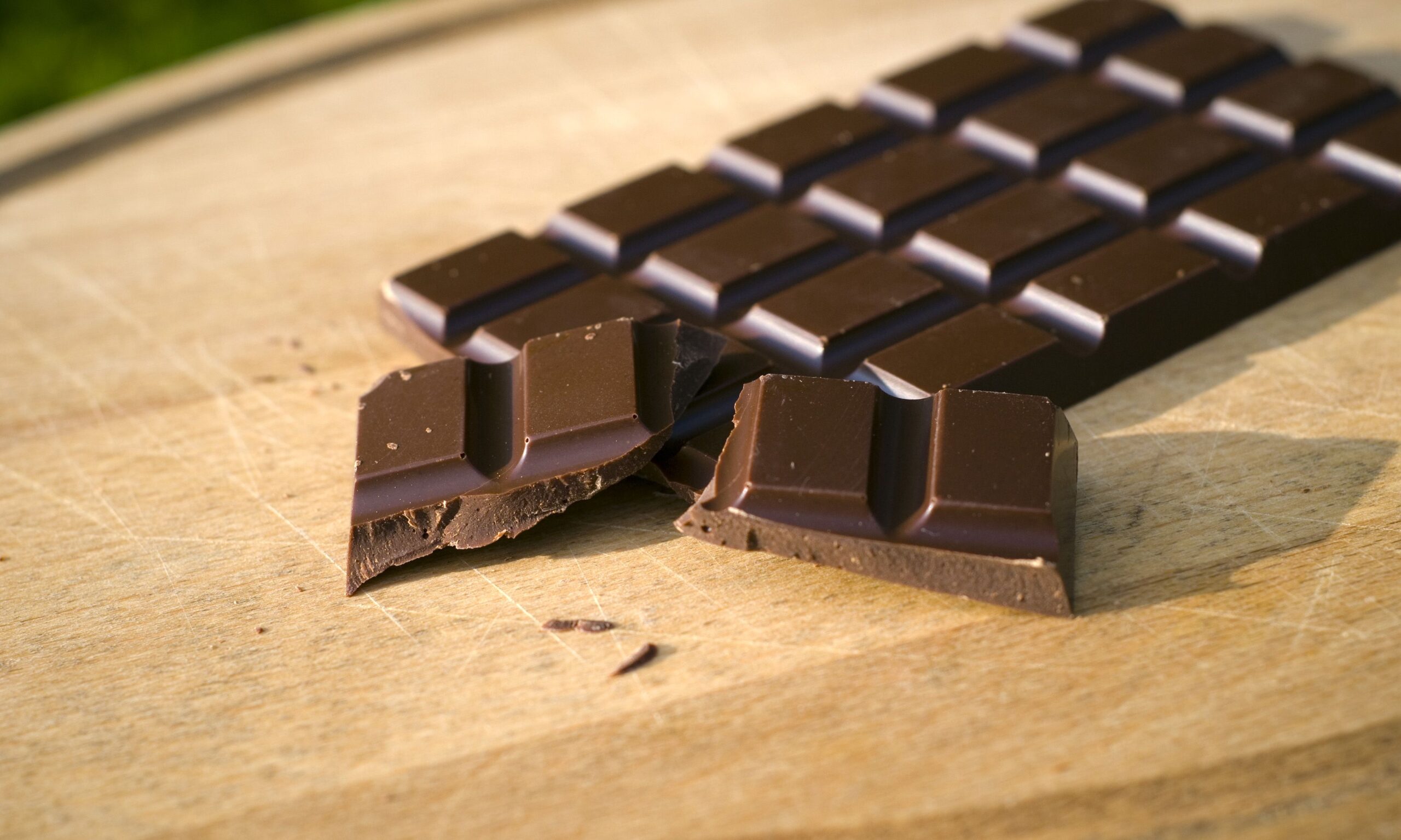 Dark chocolate candy bar on a cutting board. (SEE LIGHTBOXES BELOW for many more desserts, sweet food, baking, & snack photos...)