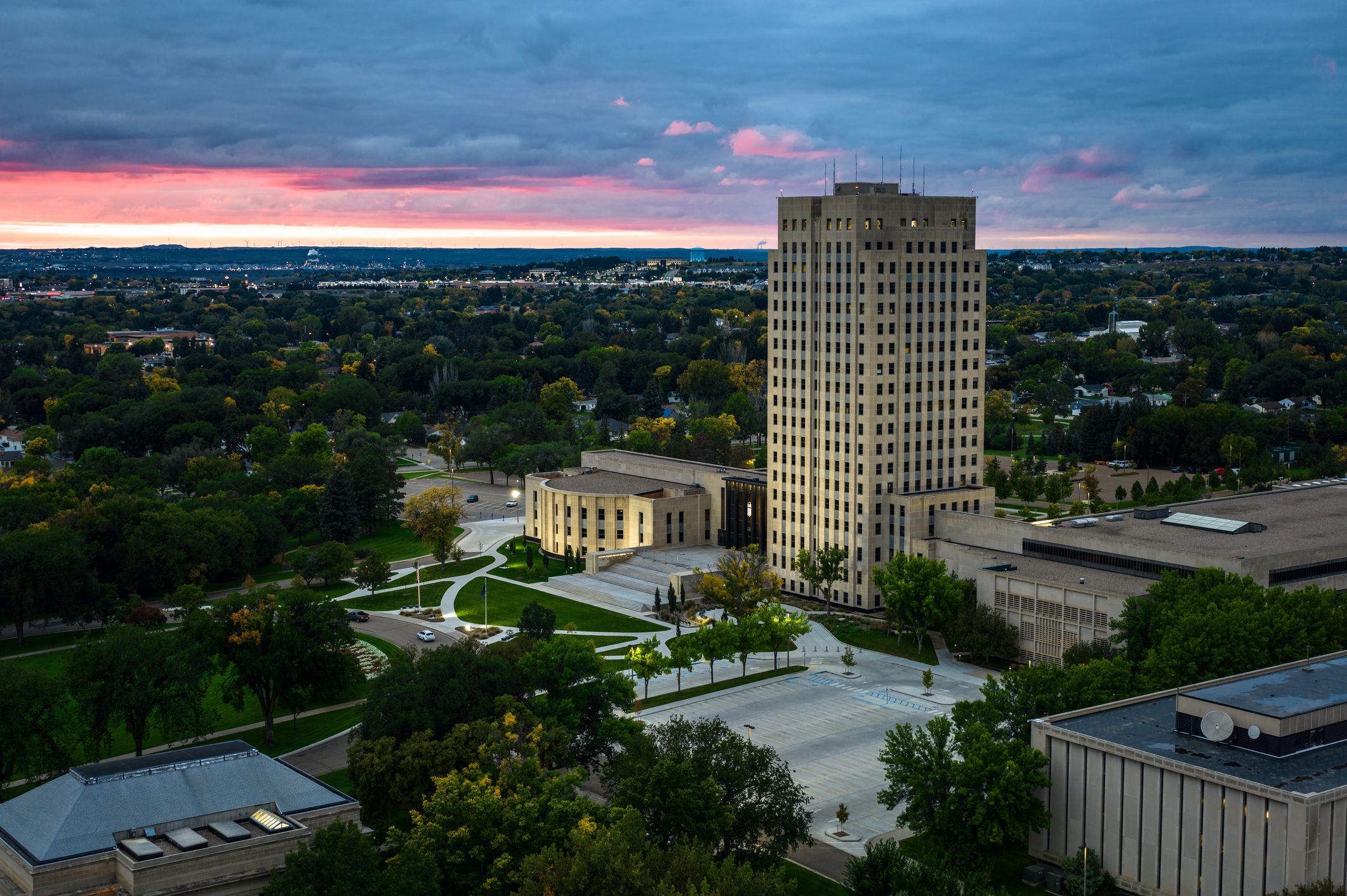 Aerial view of the North Dakota State Capitol building in Bismarck, the capital city of North Dakota, on a dramatic overcast sunset with a red tinted sky in Fall.Authorization was obtained from the FAA for this operation in restricted airspace.