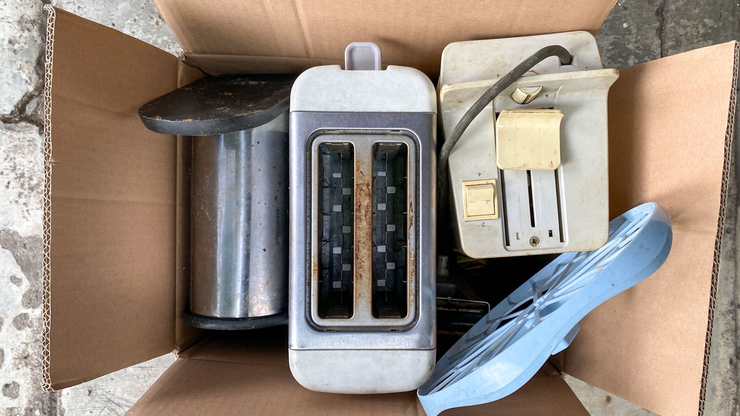 Throw away old kitchen appliances. Disposal of electrical appliances in the card box. Find it in the trash. Throw the bread toaster in the trash.