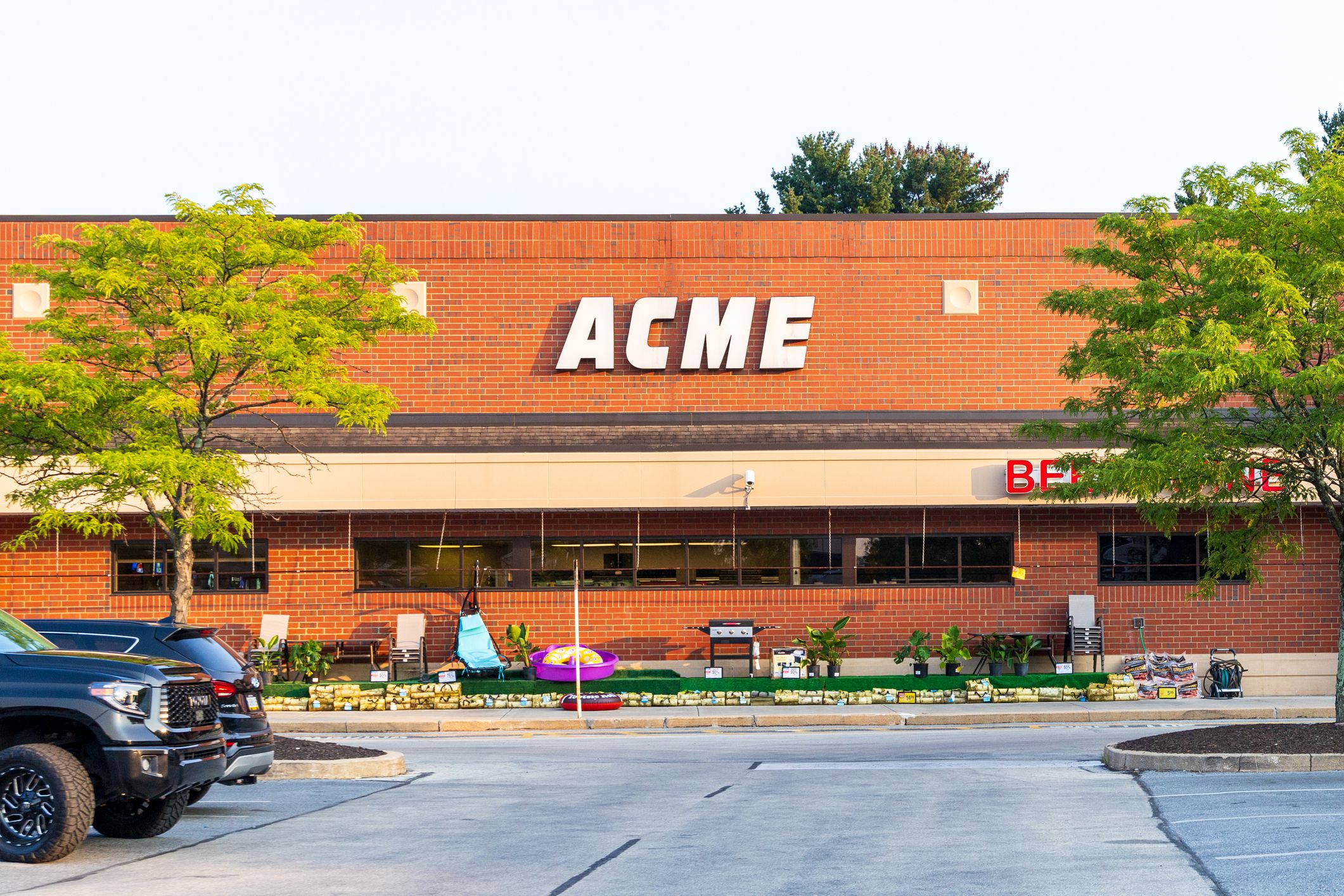 Philadelphia, Pennsylvania. USA - Ago 15th 2024: A brick building with a sign that says Acme on it. The building has a lot of windows and a green lawn in front of it