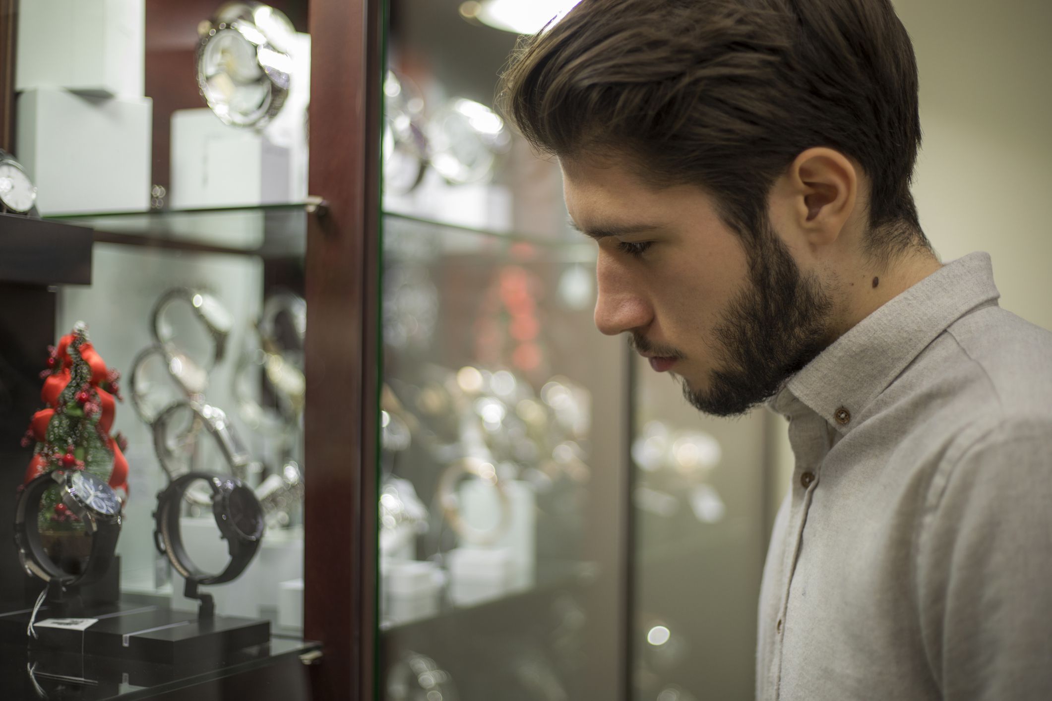young man choosing watches in jewerly store