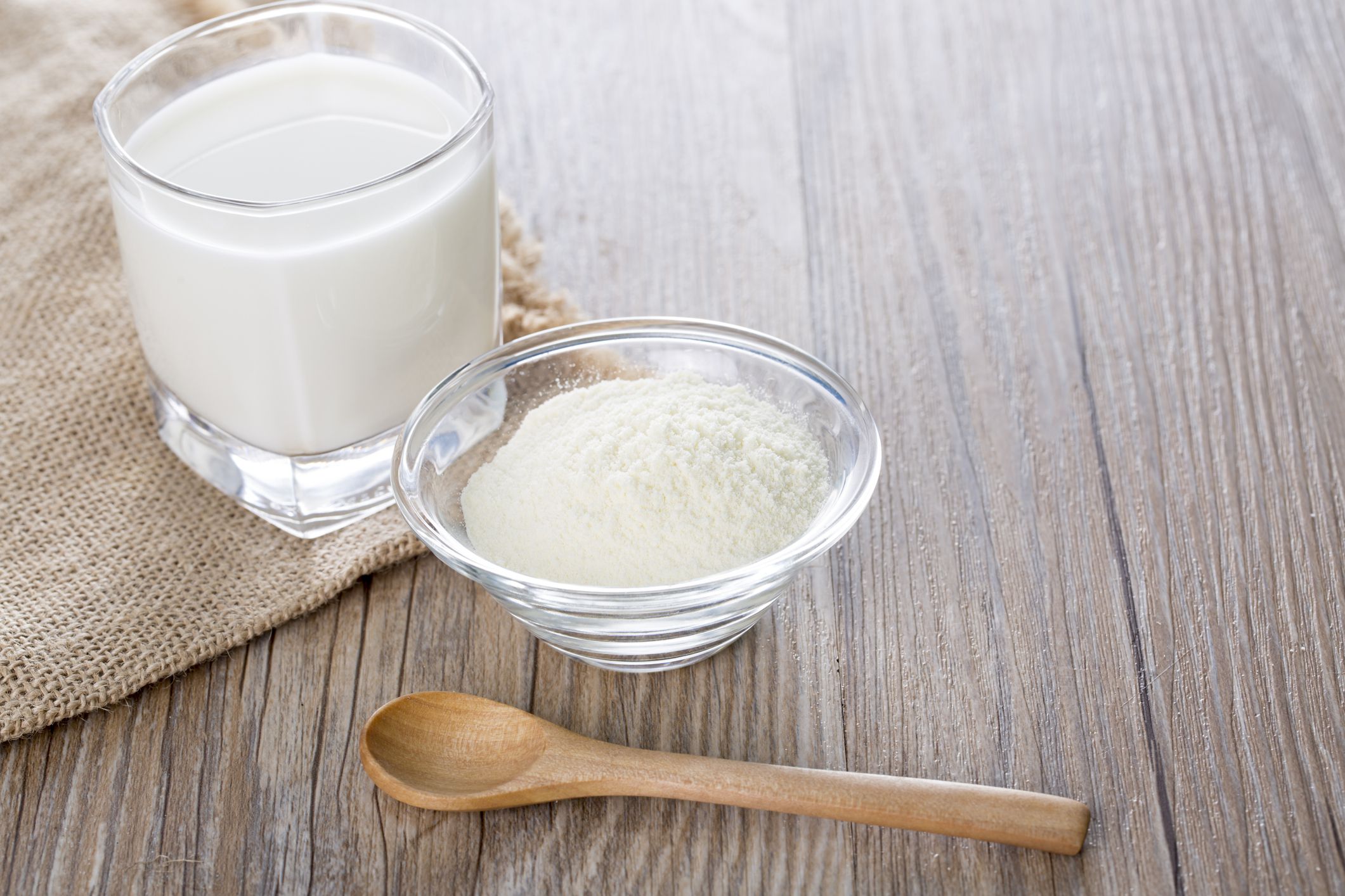 Cup of milk and powdered milk on the table.