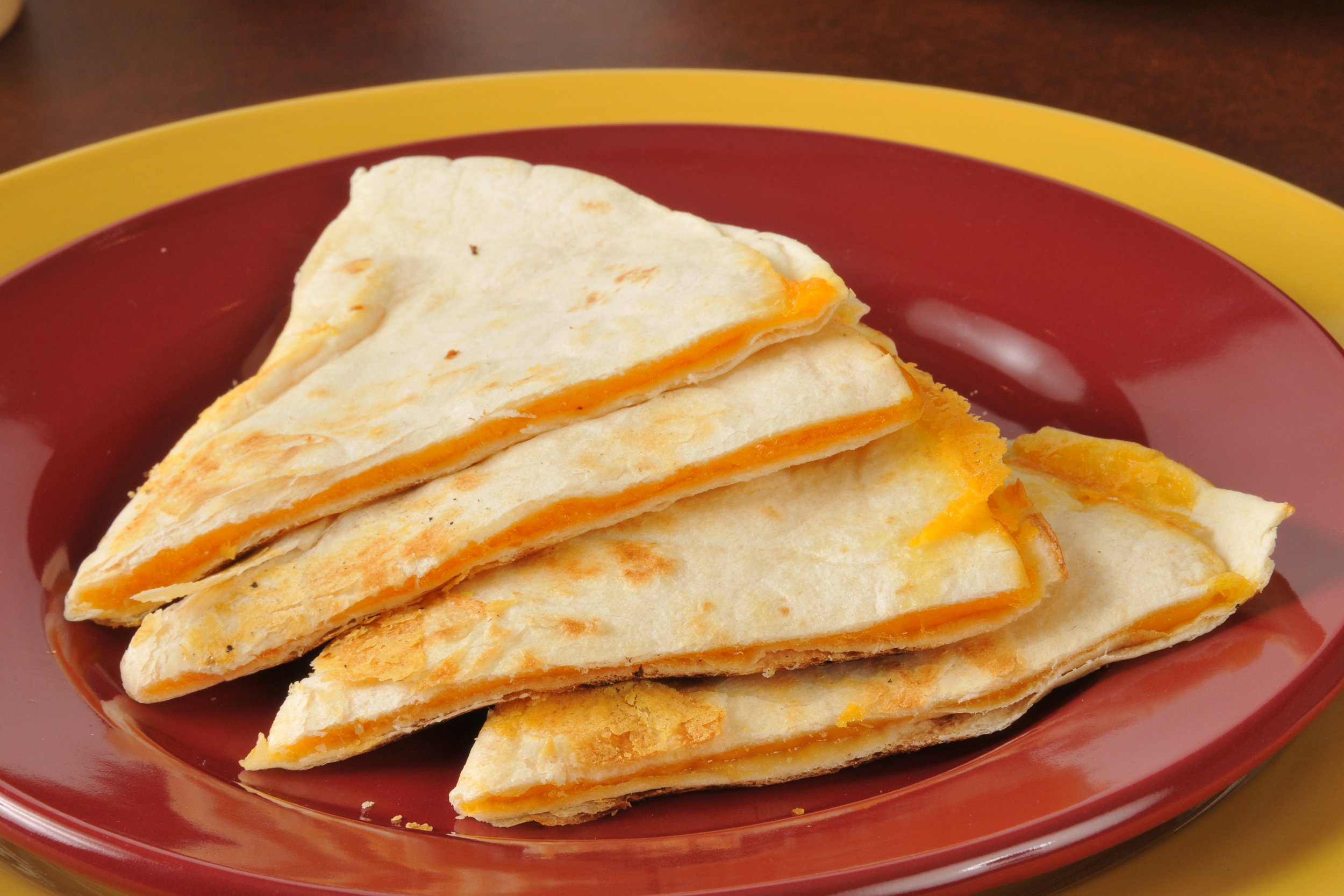 Plain cheese quesadillas on a red plate