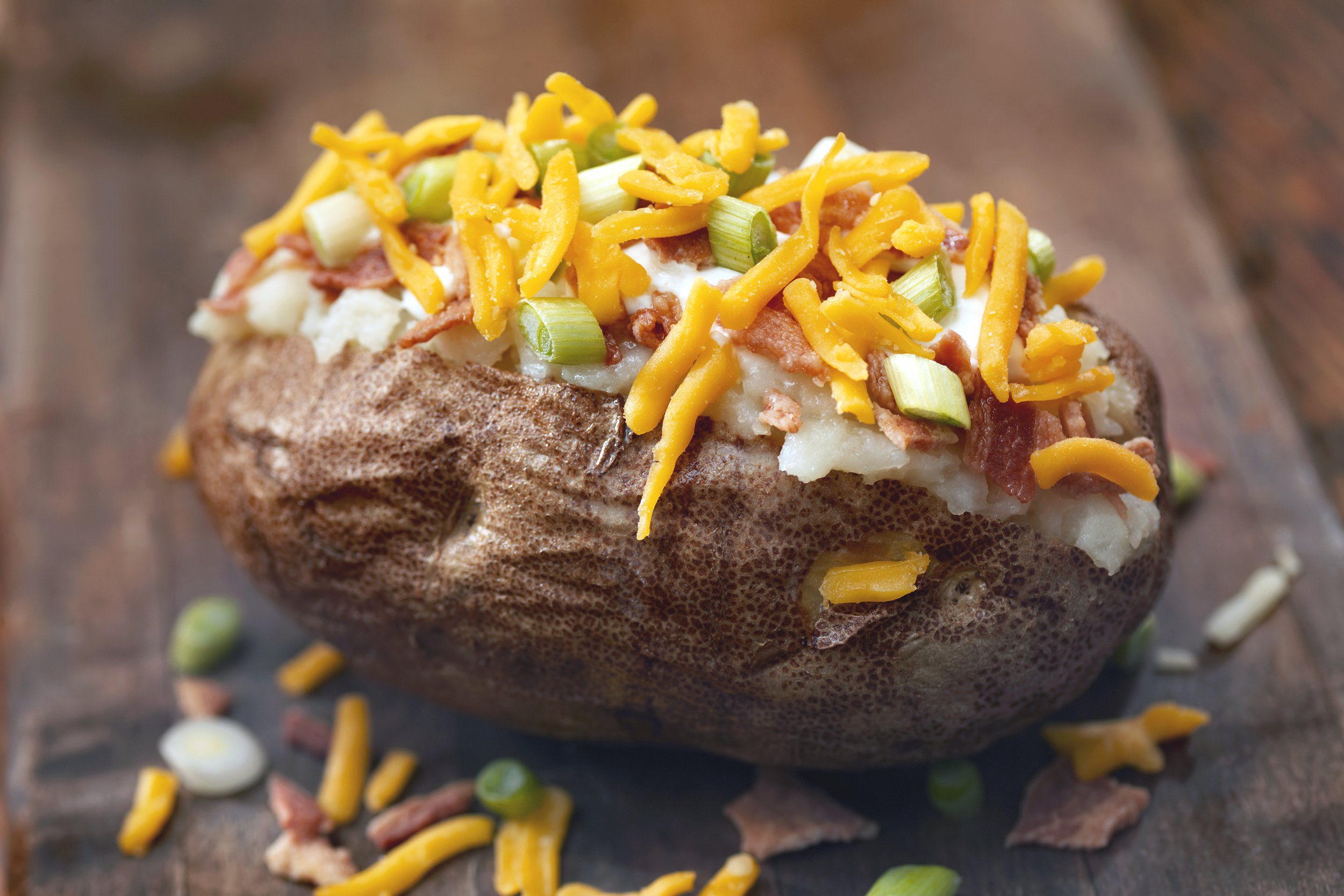 Baked potato with cheese, bacon, and green onion