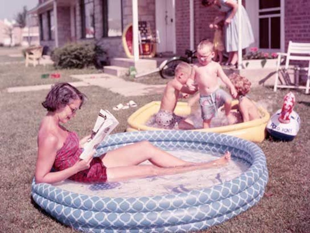 family with inflatable pools in the front yard