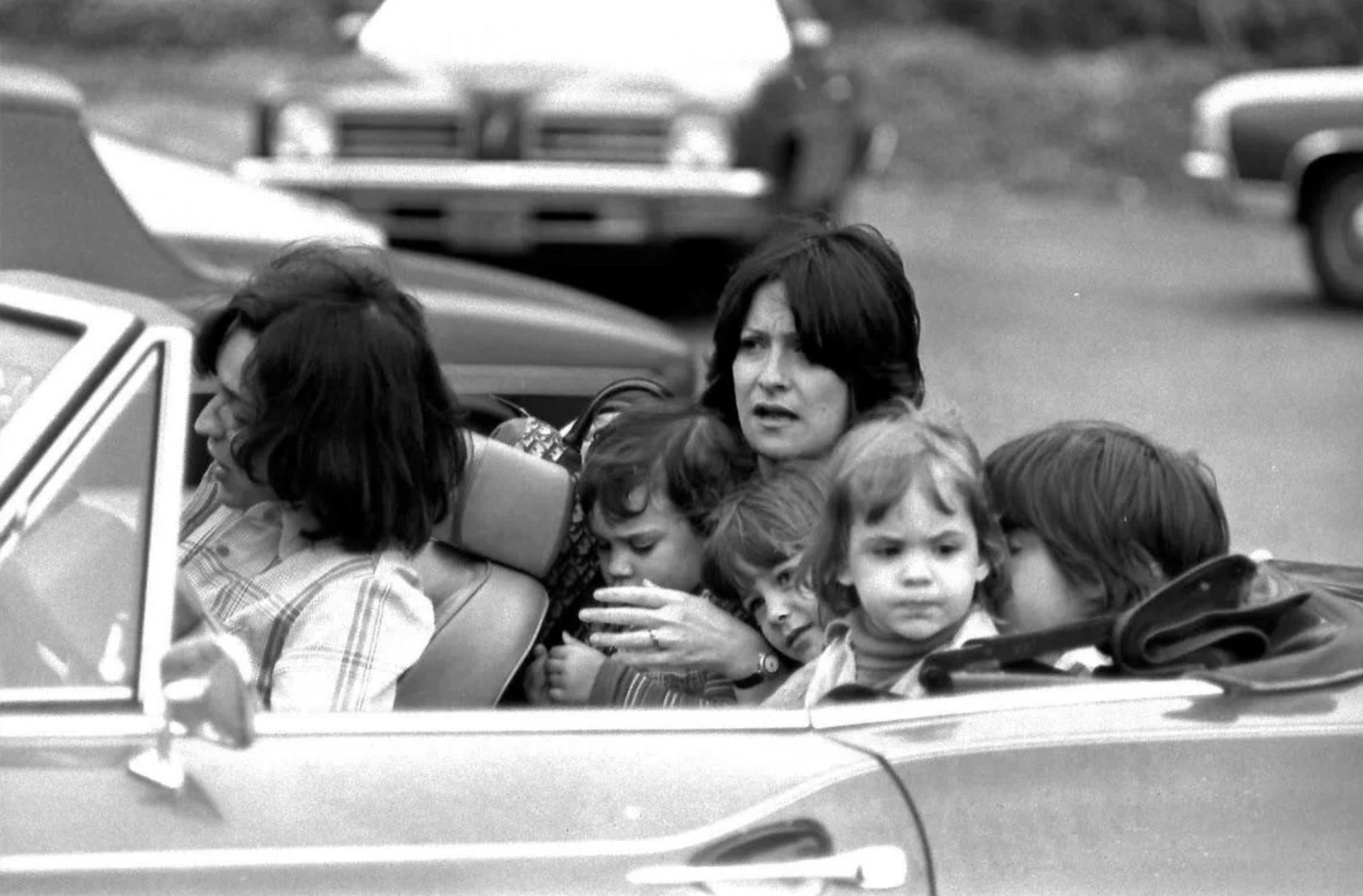 My mom in the back of our fiat with her Dior bag, 4 kids, no seat belts…I’m the one in her lap