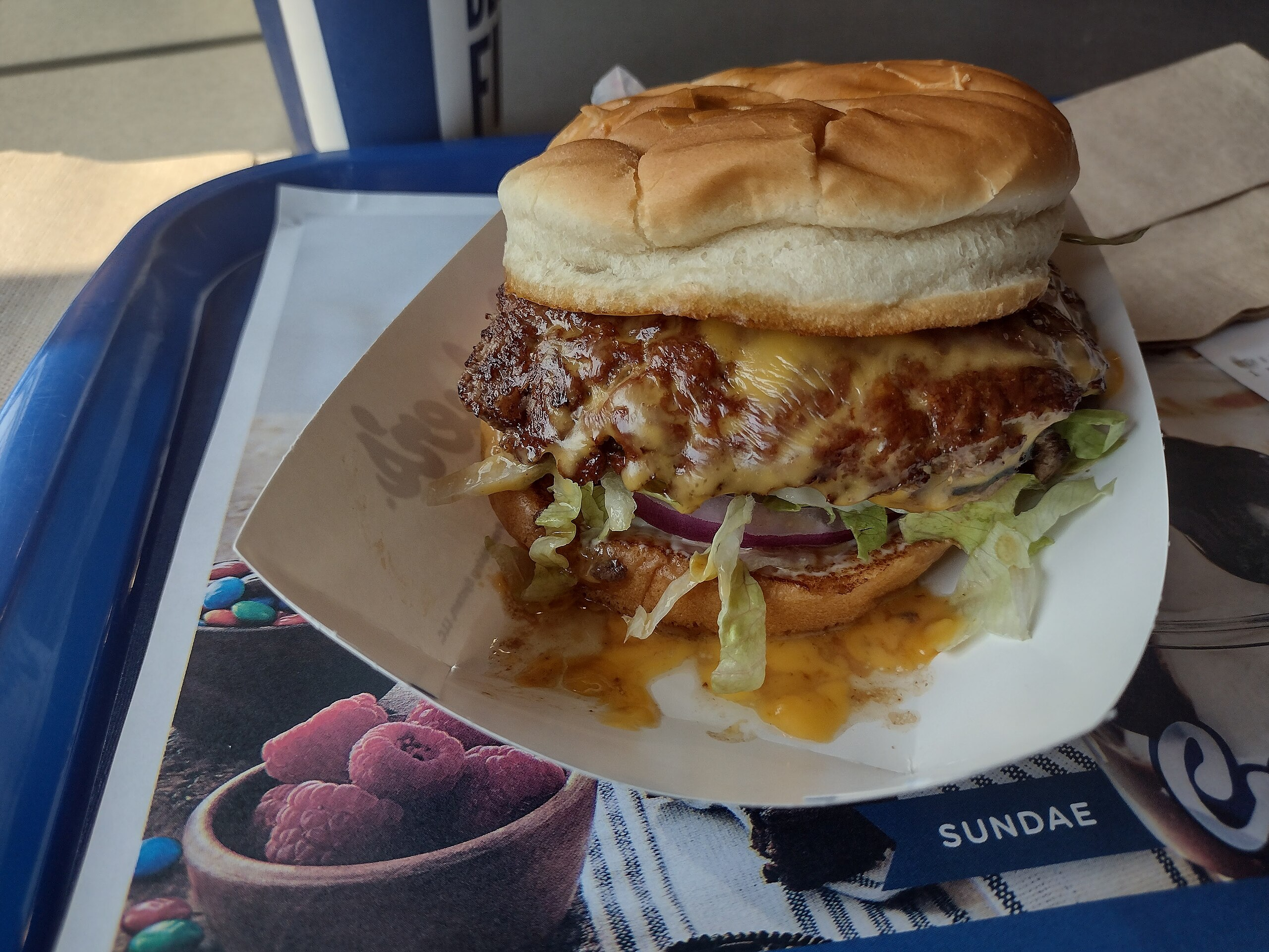 Culver's ButterBurger Deluxe With Cheese Sauce on a Serving Tray at the Restaurant