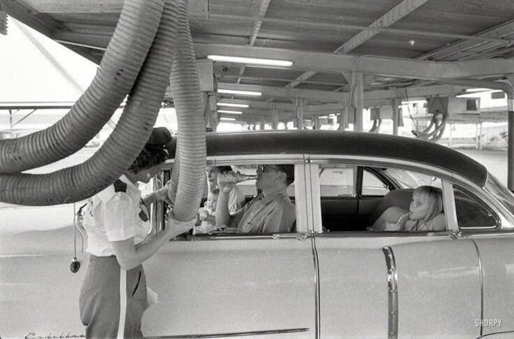 Getting cooled air piped into the car while enjoying a meal at a drive-in restaurant. Houston, Texas, 1957. Literally old school cool.