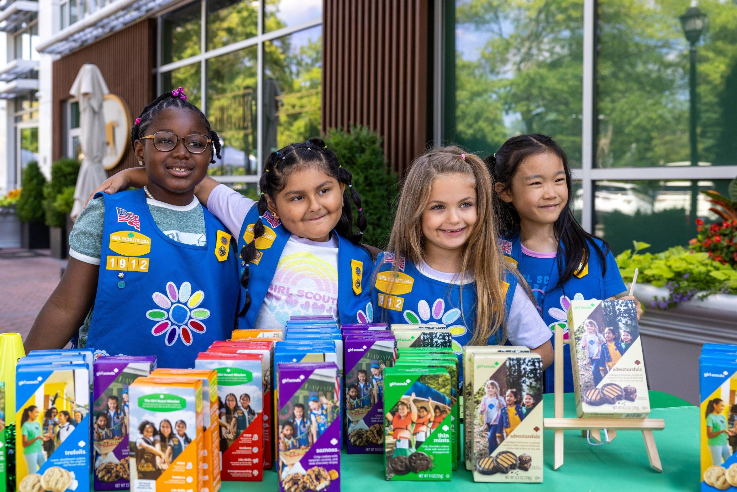 Girl Scout Troop selling cookies with arms around each other
