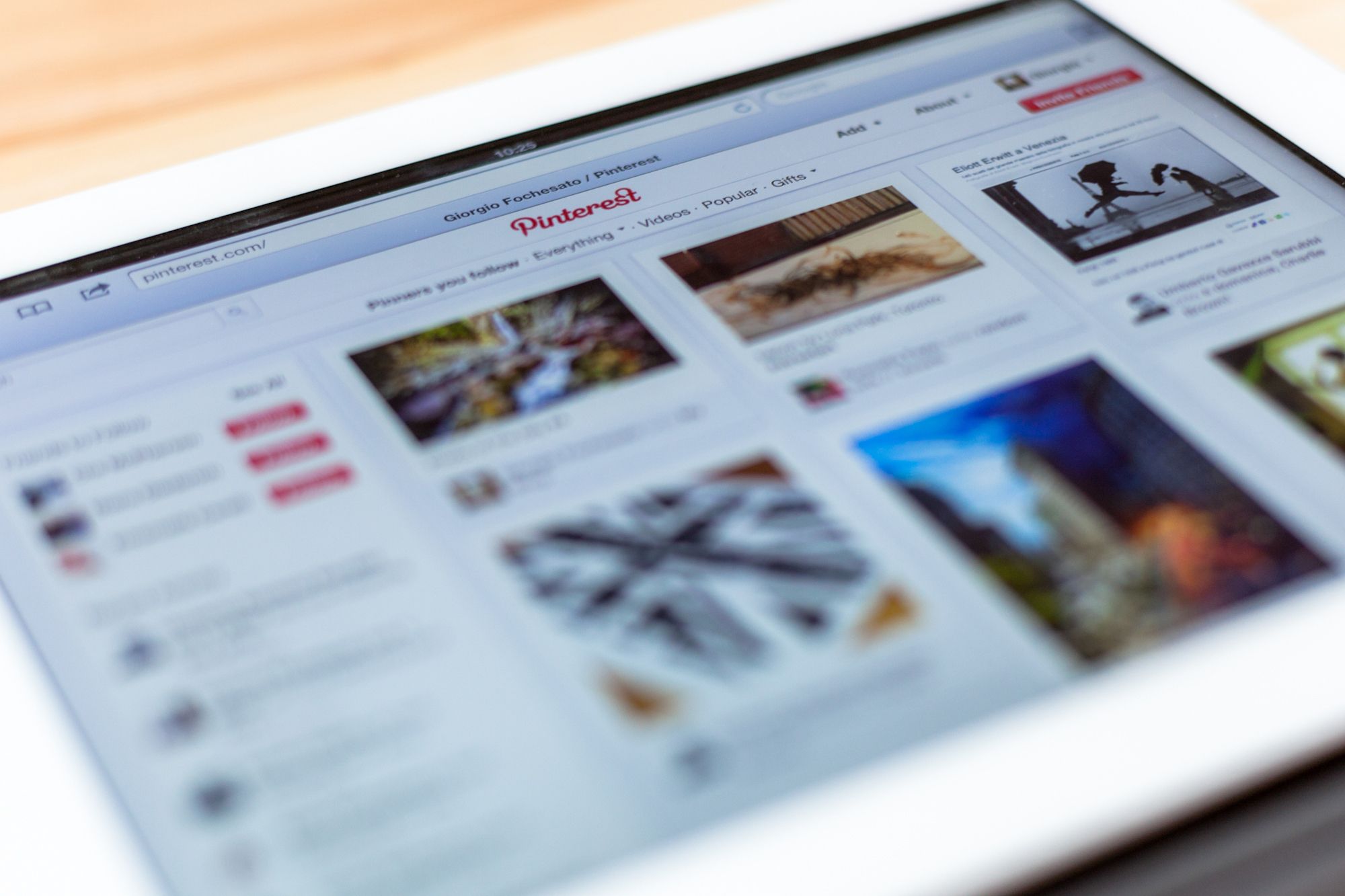 Pinterest in Safari browser on a white 3rd Gen iPad, selective focus, on a light brown table blurred