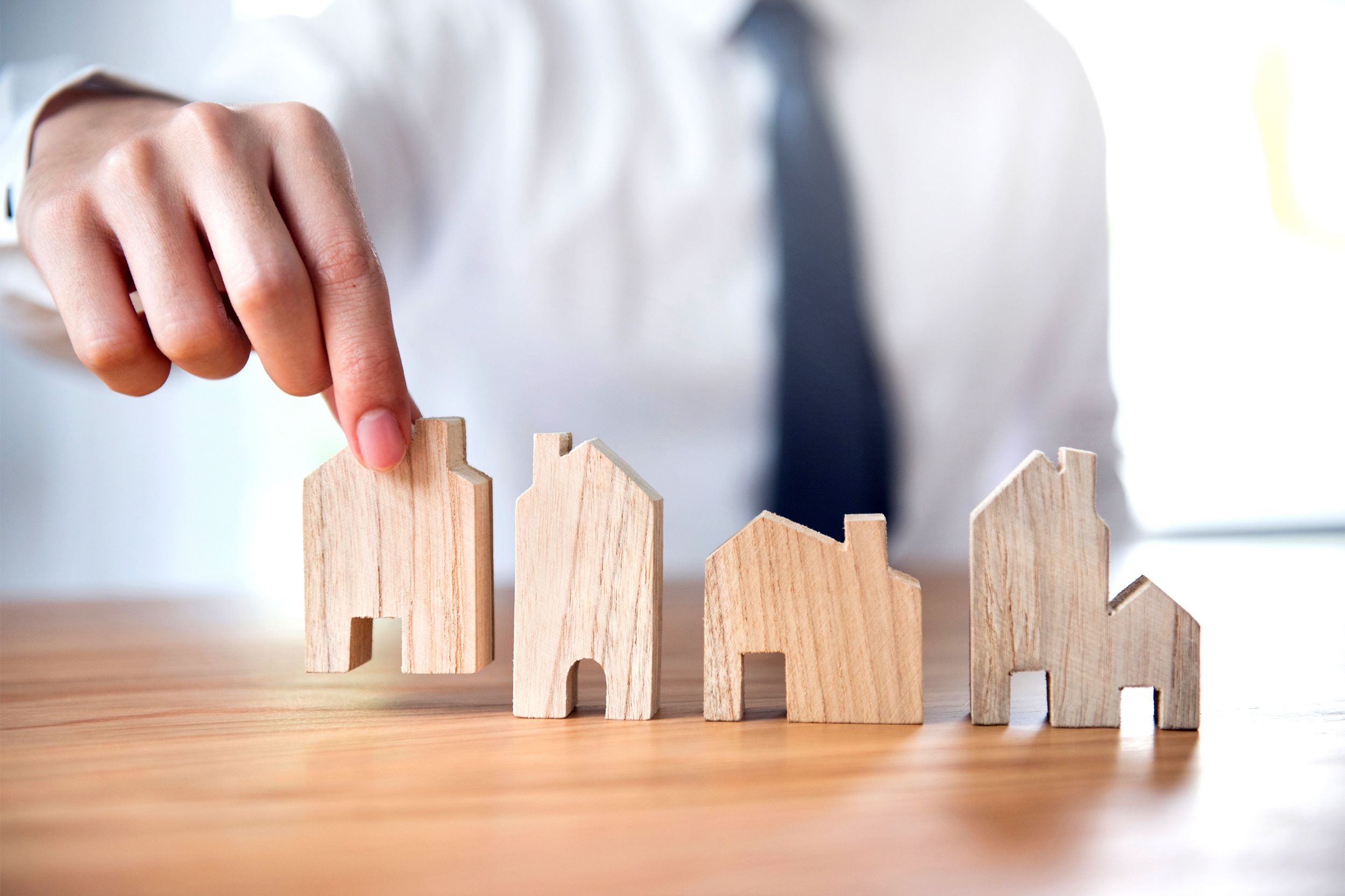Hand of businessman choosing house model