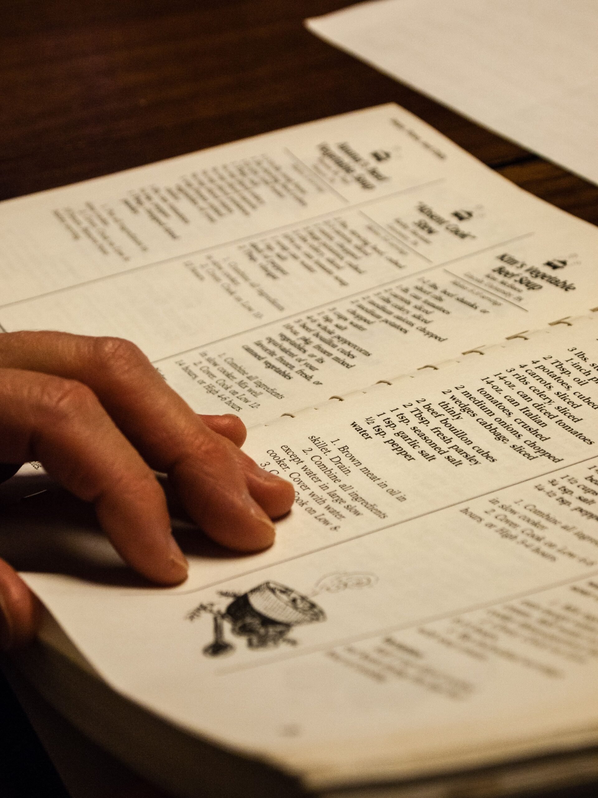 Close up of a person holding open a recipe book.